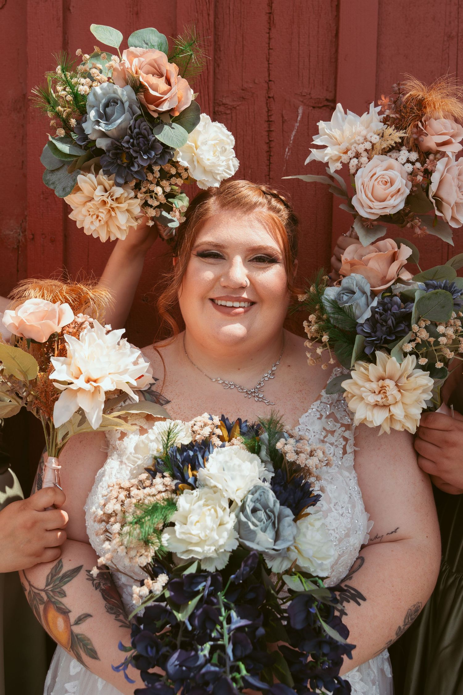 Wedding bouquet detail shots featuring peach, white and blue flowers with a red barn wall backdrop.