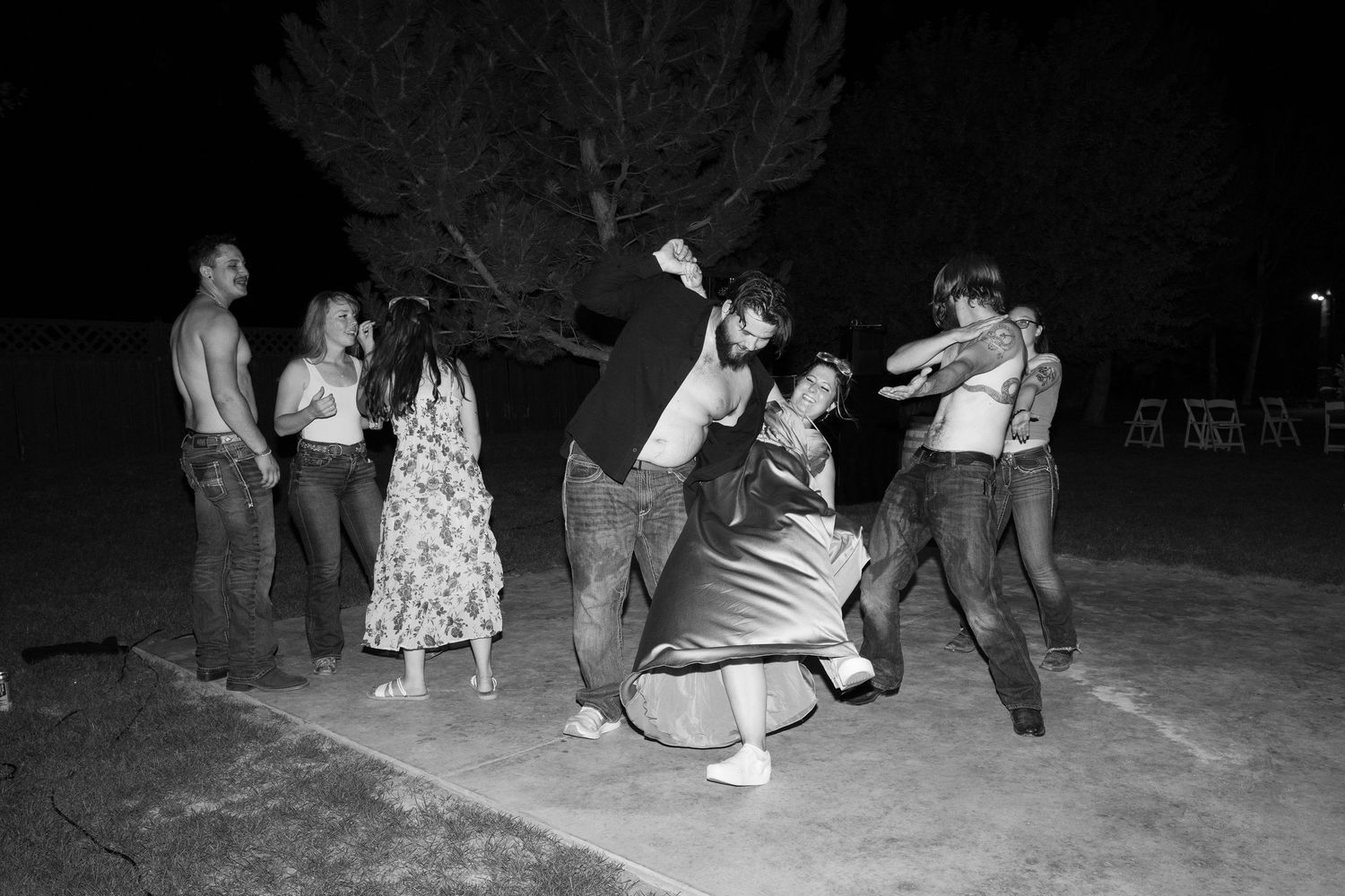 Wedding celebration continues into the night as guests dance under dark skies.