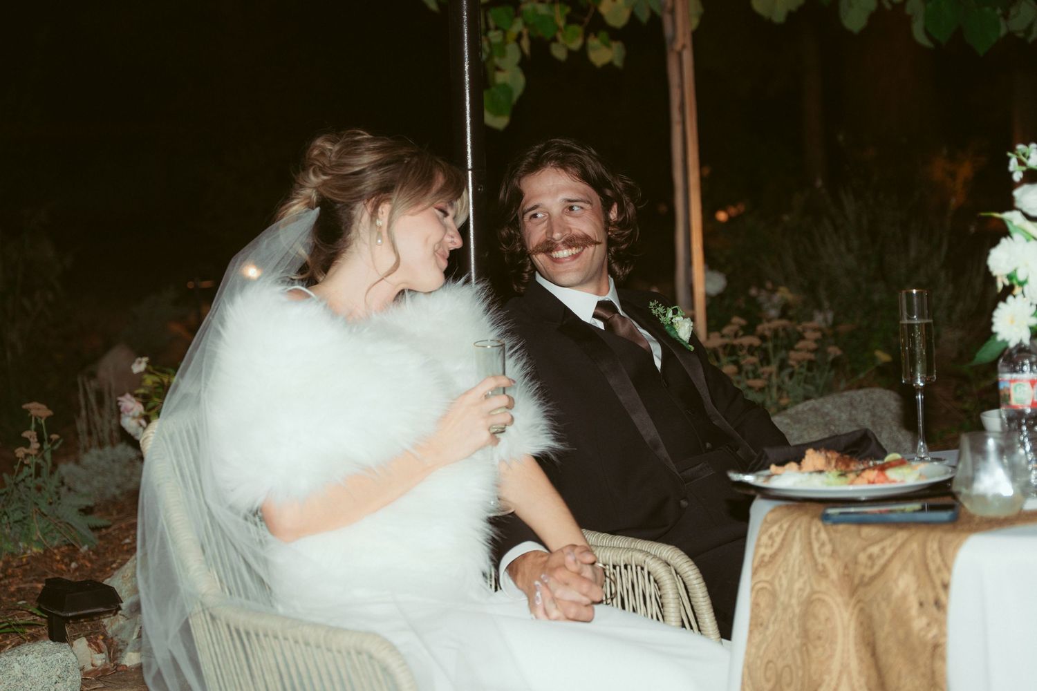 Wedding couple enjoying their reception at a beautifully decorated outdoor venue.