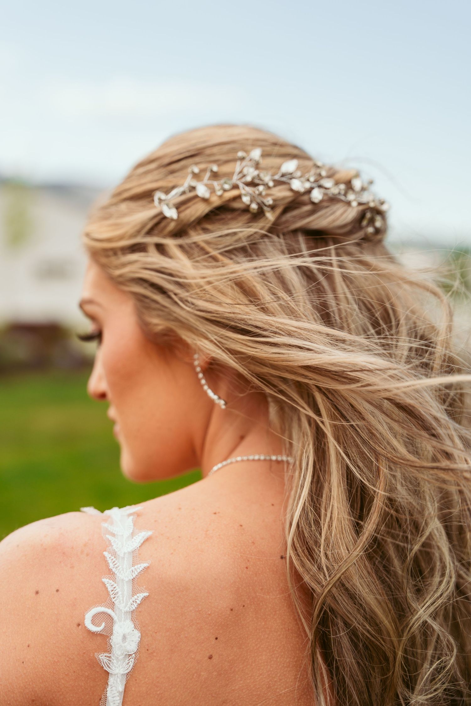 Close-up of intricate bridal hair accessories and lace dress detail.