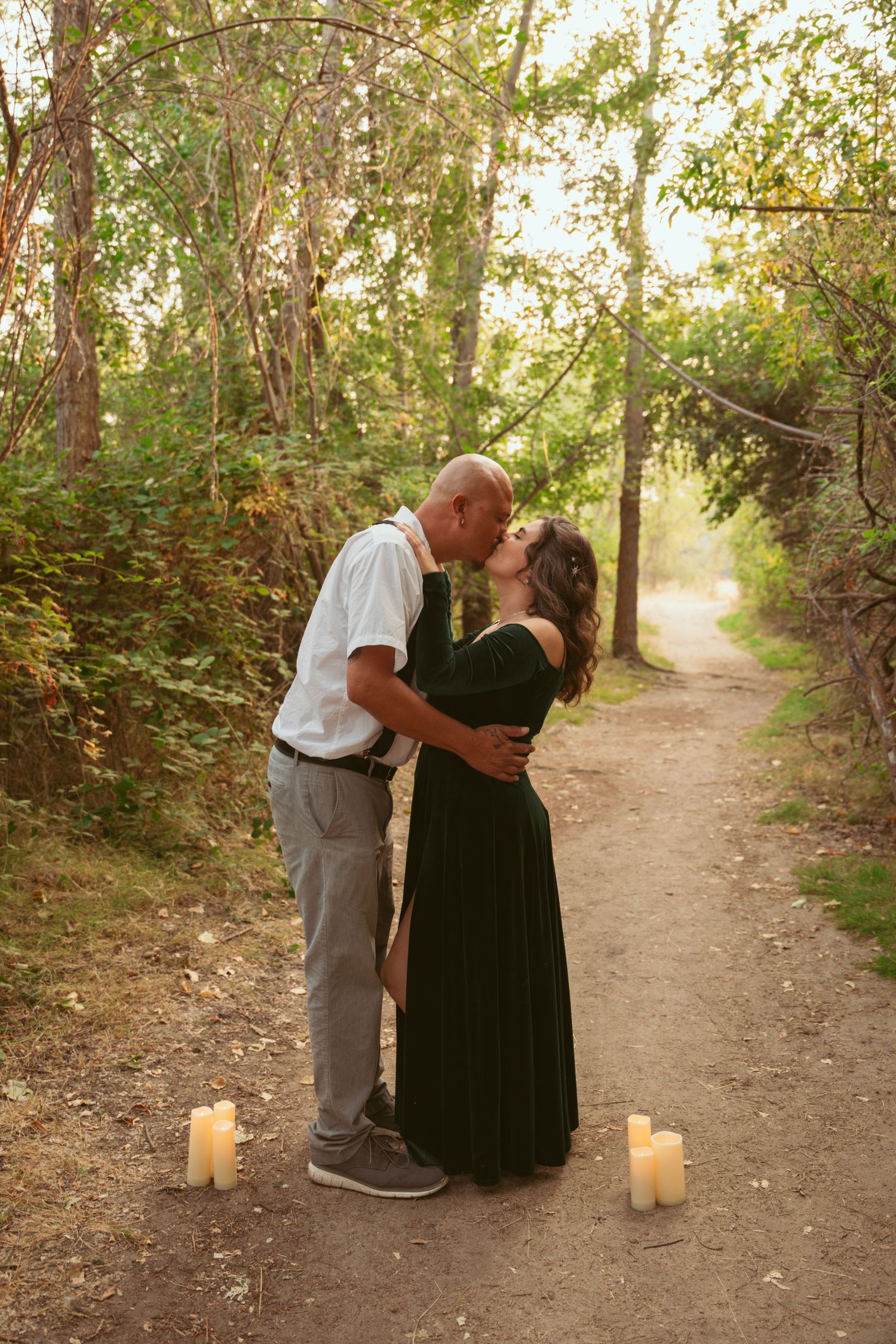 A romantic path lit with candles creates an intimate setting in the woods.