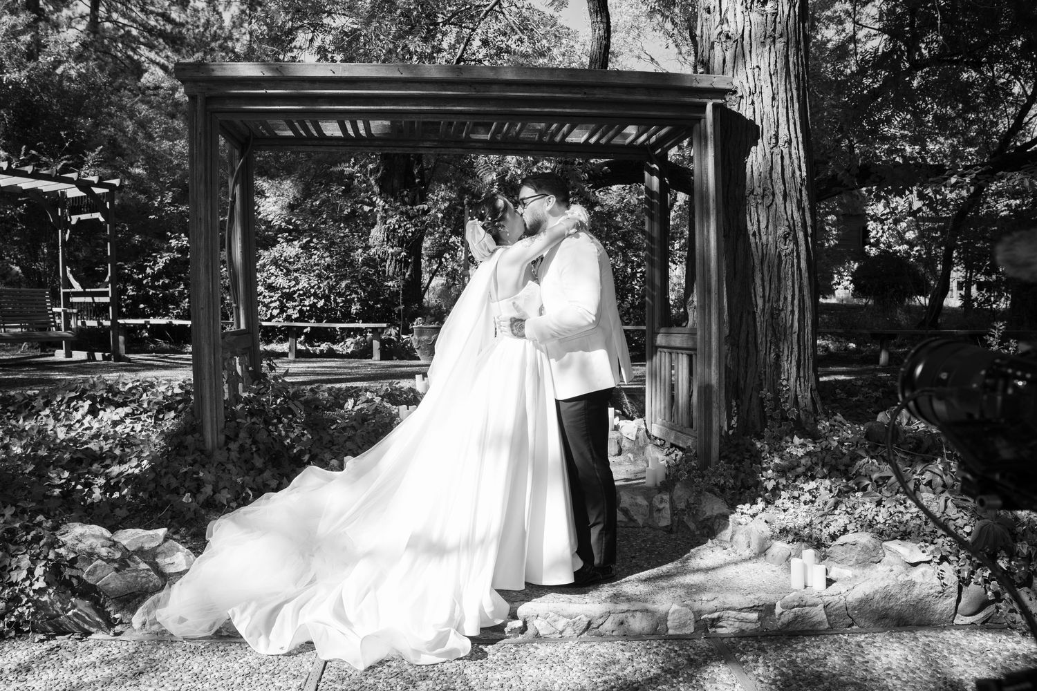 Black and white wedding photography series captured in natural outdoor garden setting.