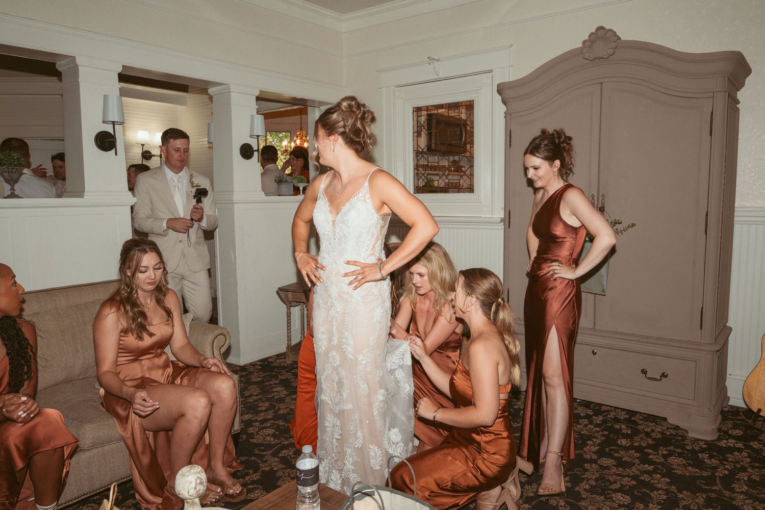 Wedding party members sharing emotional moments in an indoor venue.