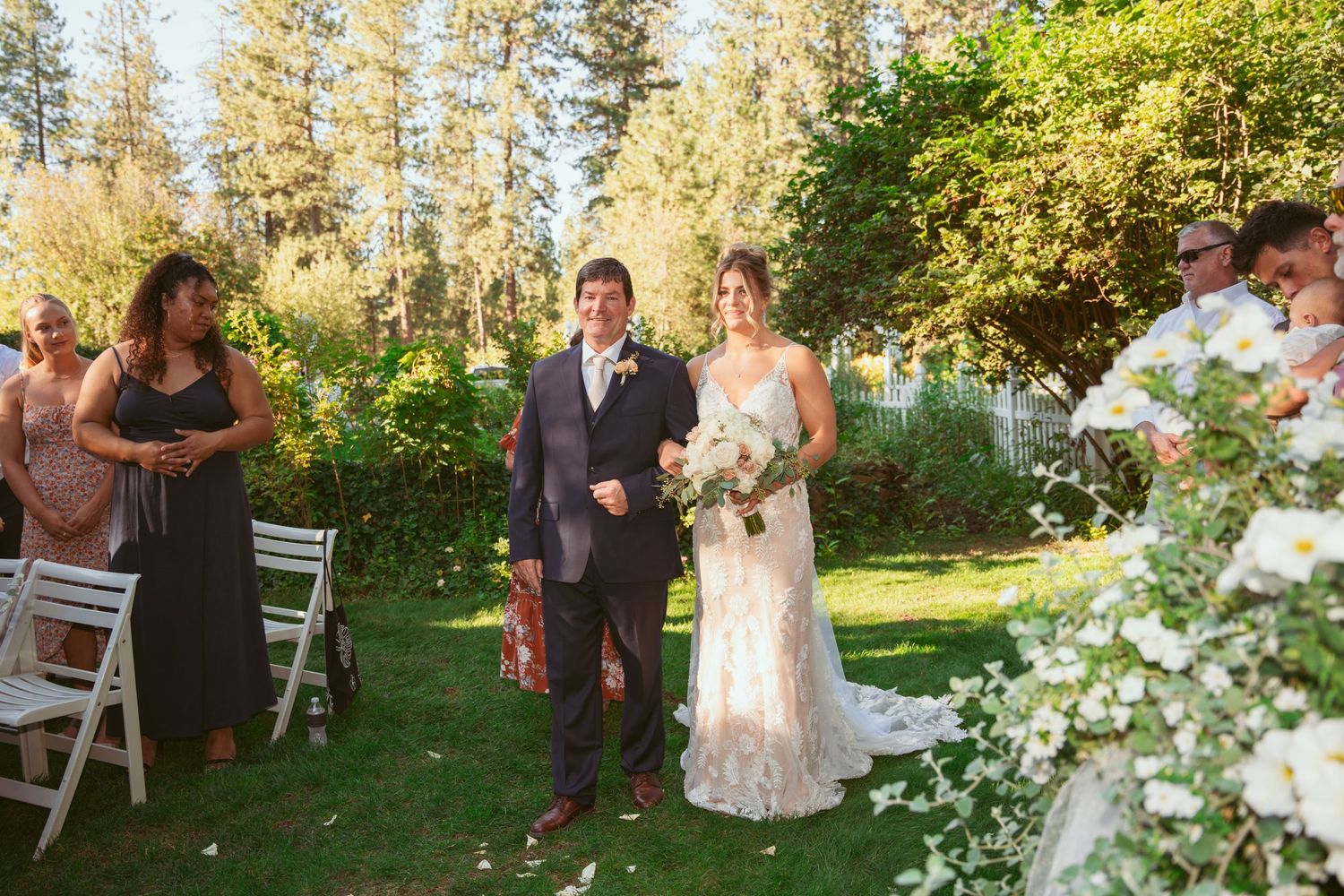 Wedding ceremony sequence showing joyful celebration under tall pine trees on a sunny afternoon.