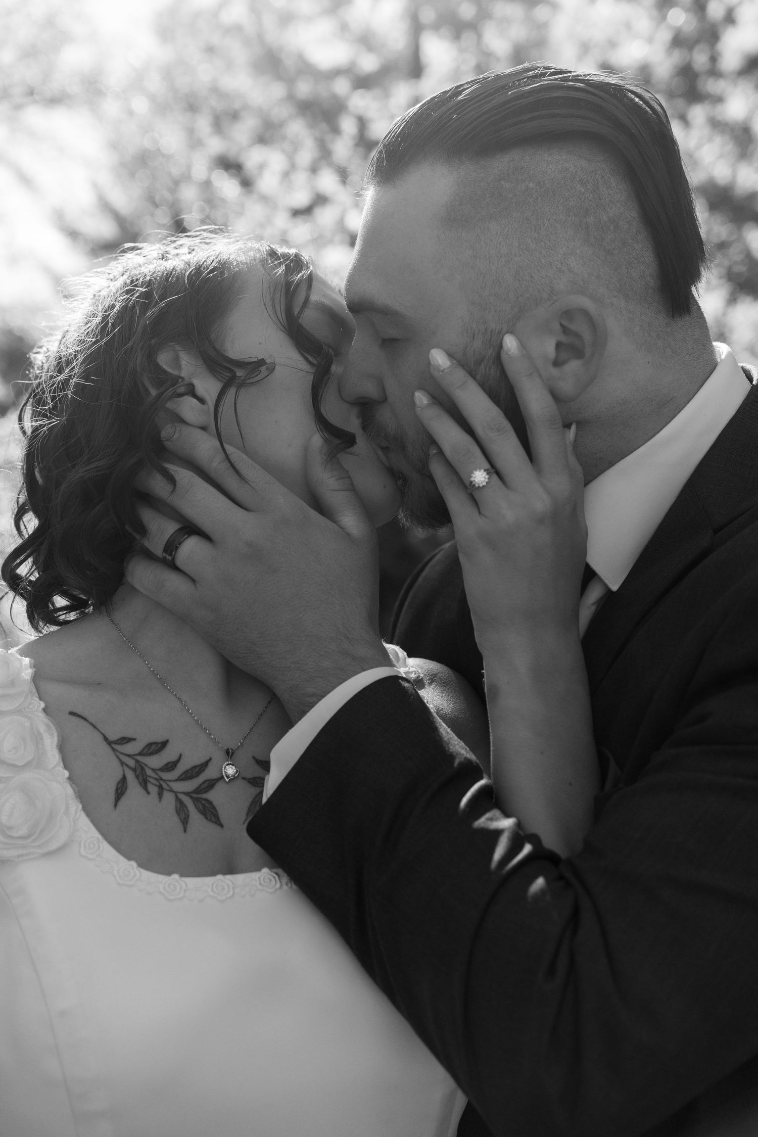 An intimate black and white portrait of a wedding couple sharing a passionate moment.