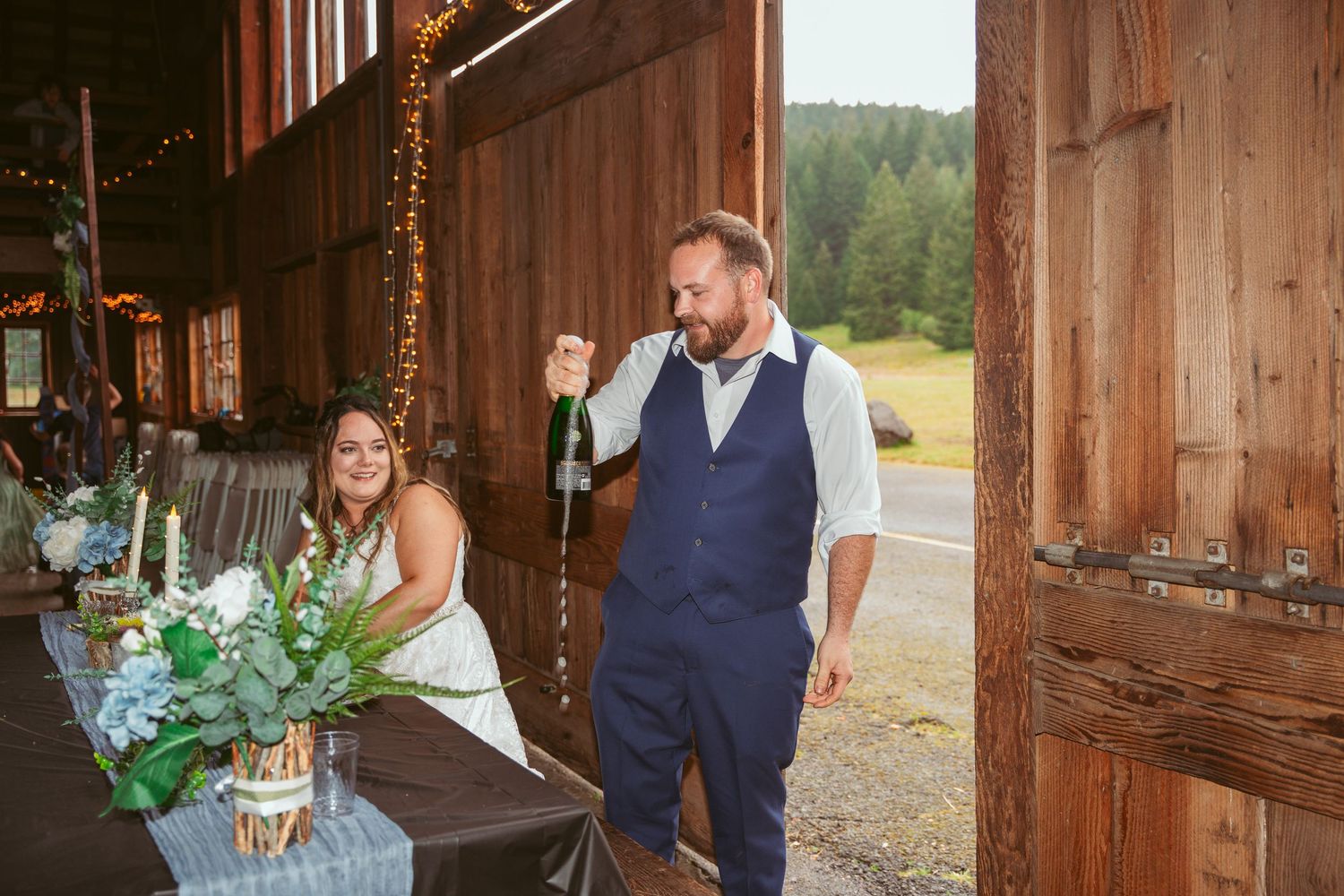 Wedding celebration in a rustic barn venue with natural light streaming through windows.