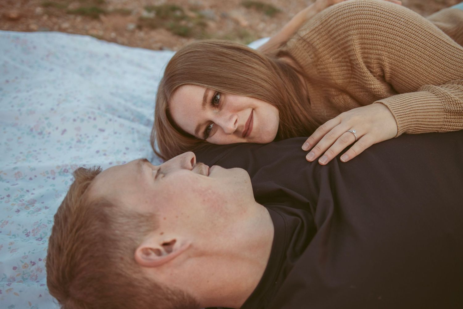 Intimate close-up portraits of couple laying on blanket outdoors.