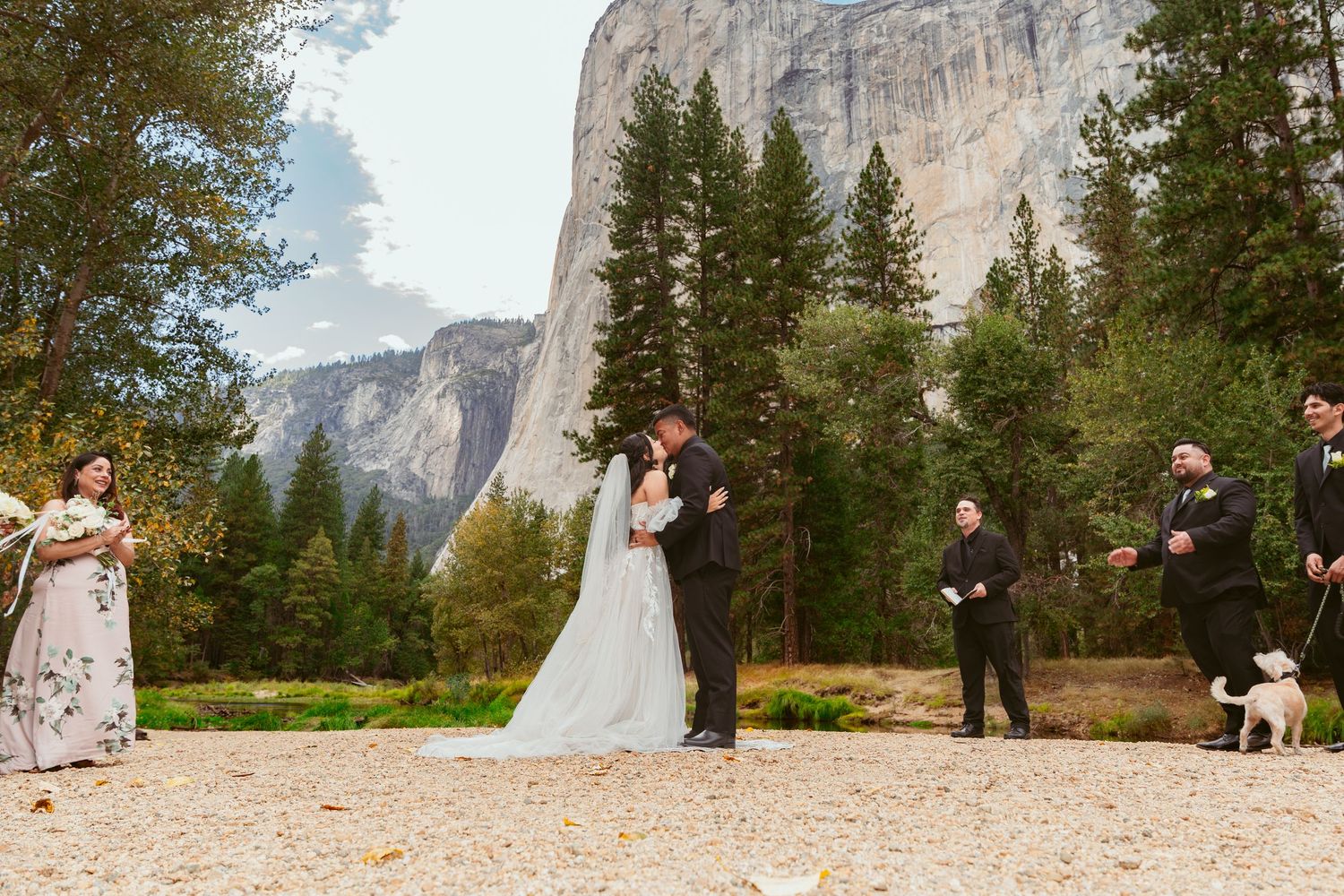 Wedding ceremony in Yosemite Valley with towering granite cliffs and evergreen trees creating a majestic backdrop.