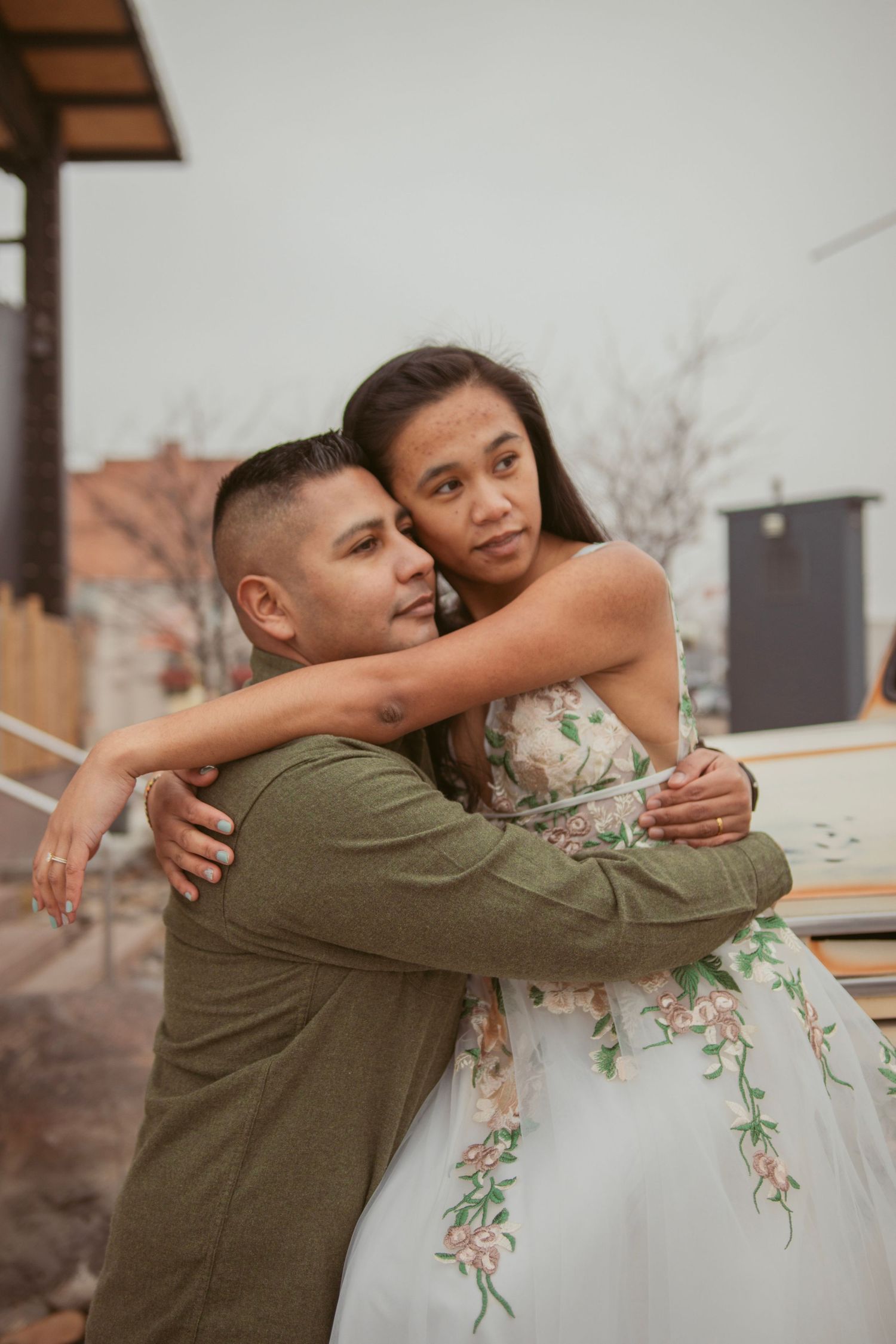 A tender embrace captured in a series of wedding photos outdoors.