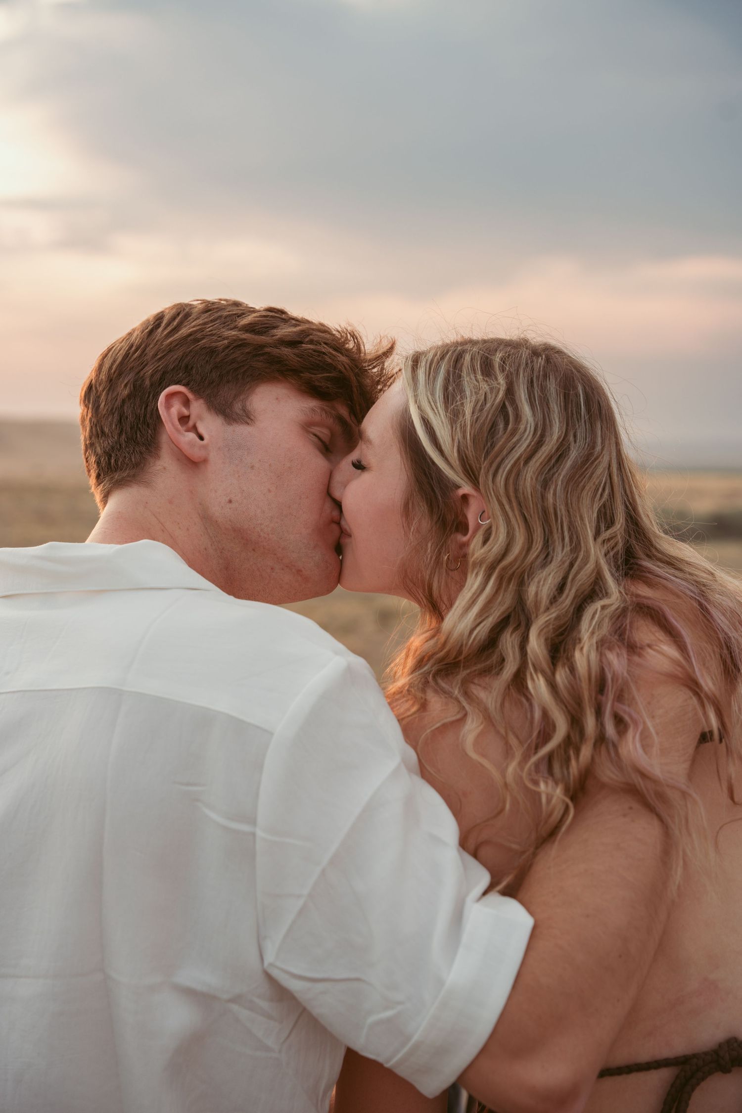 Intimate couple moment captured during sunset desert photoshoot.