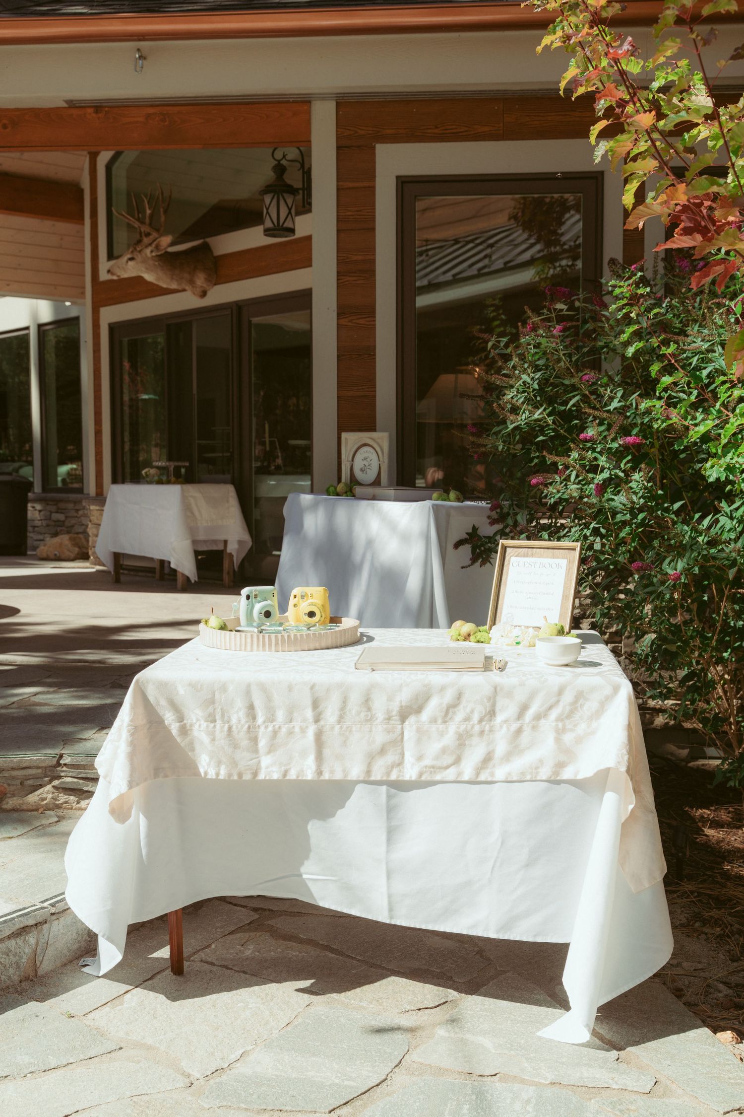 Long white-clothed tables set up outdoors for a wedding reception.