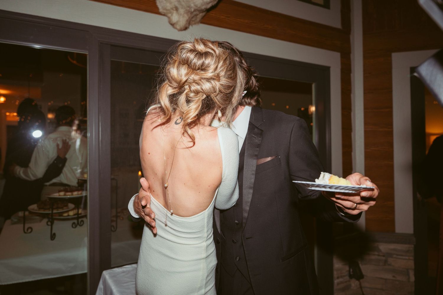 Wedding couple shares a fun cake-feeding moment during their reception.
