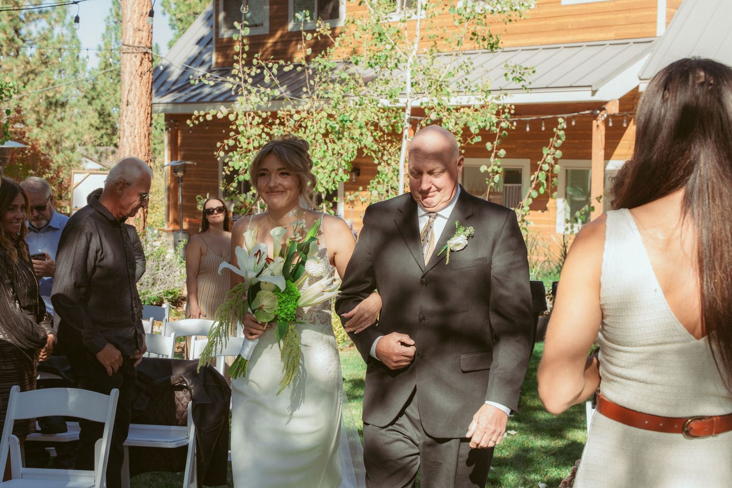 Wedding ceremony participants standing in formation during an outdoor garden event.