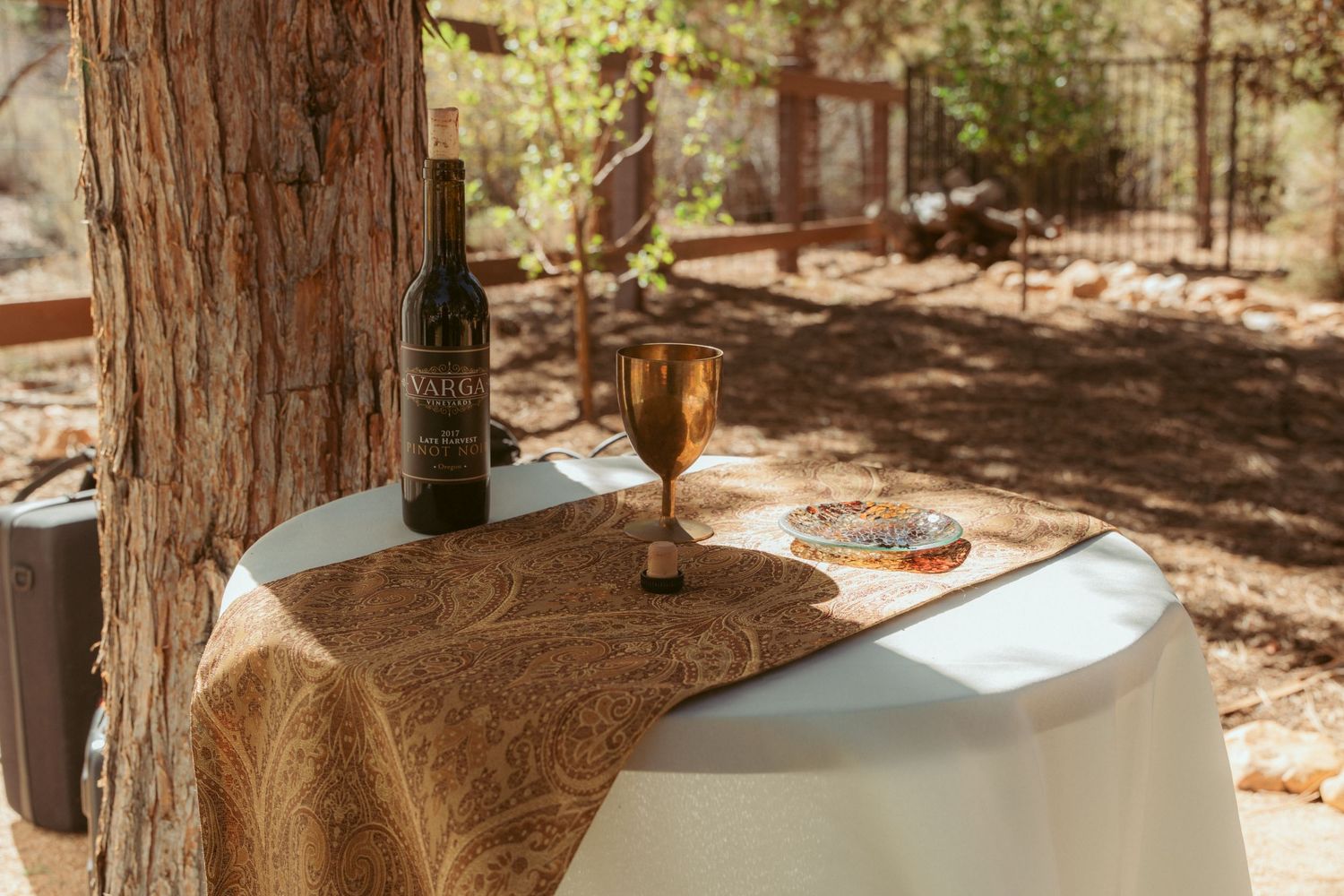 Outdoor wedding reception tables set among towering redwood trees.