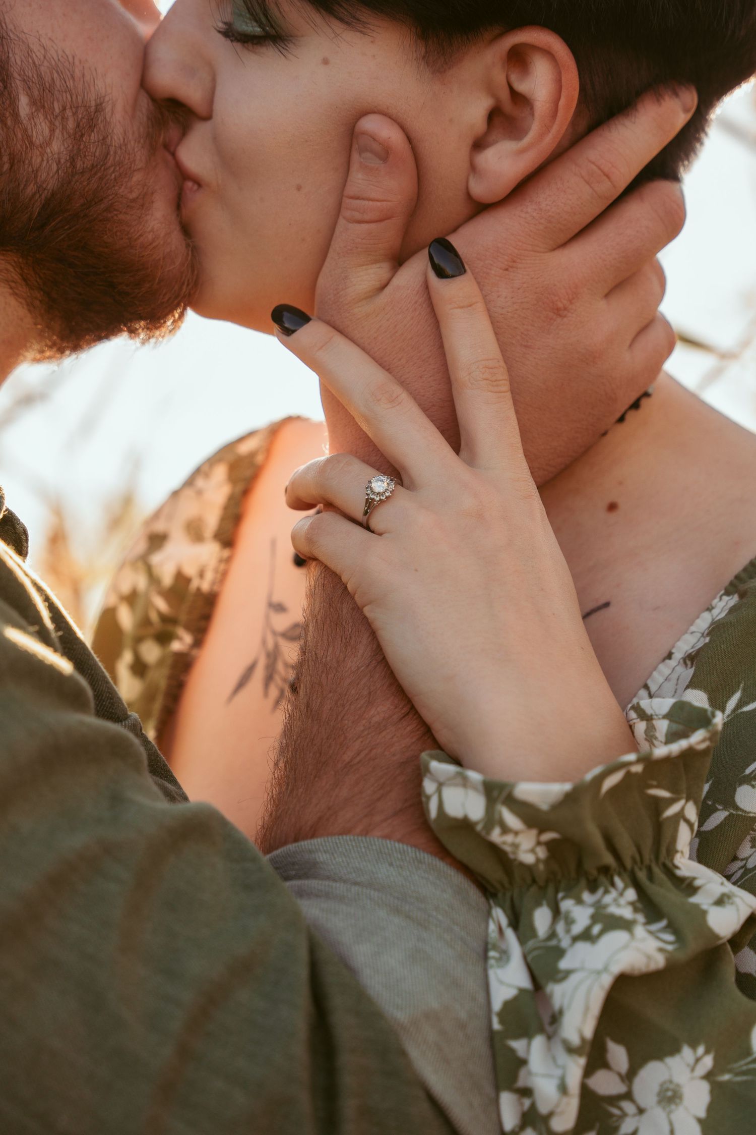 A tender close-up moment between two people against a warm sunset backdrop.