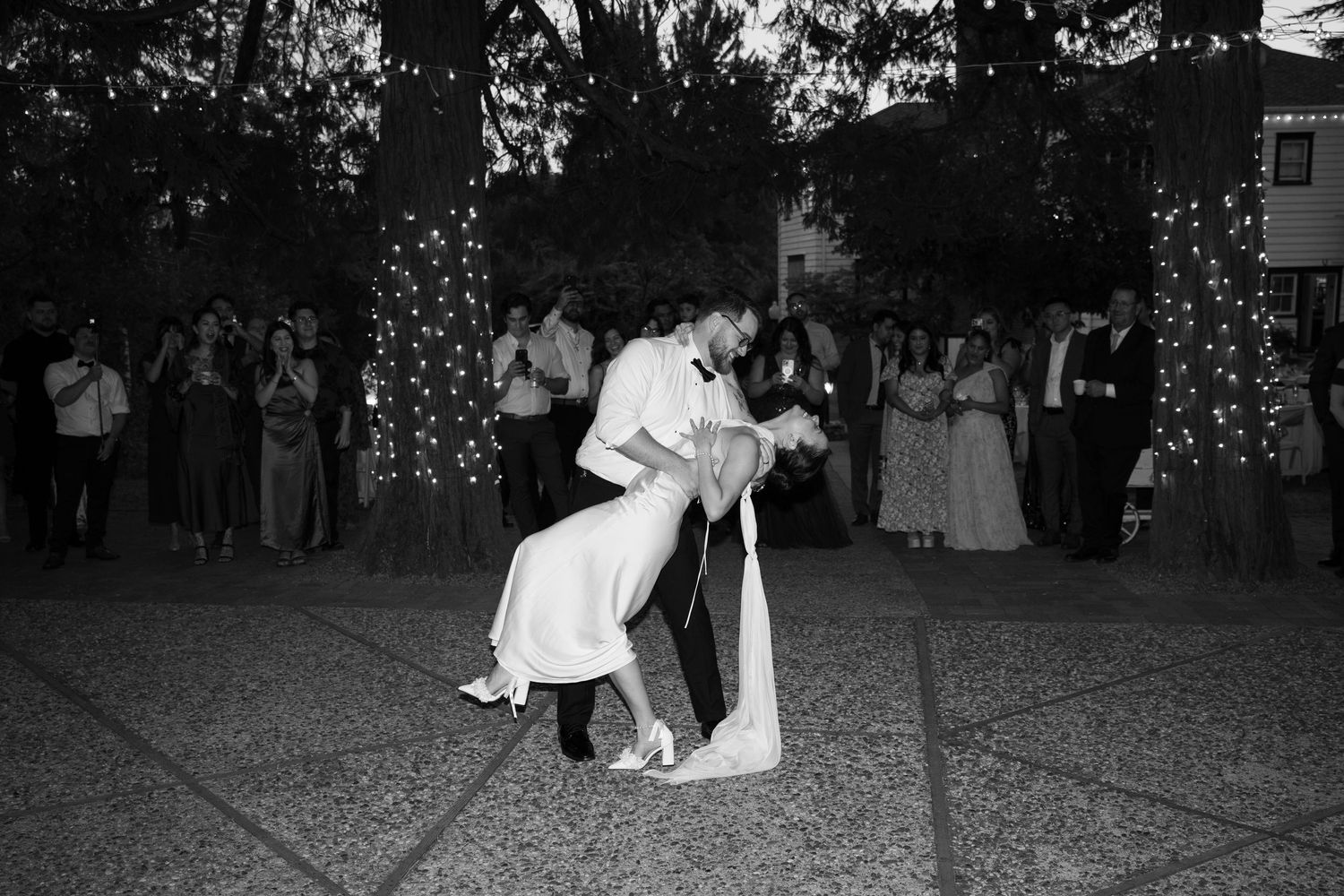 Black and white photo of a couple dancing together at what appears to be a wedding reception or formal event.