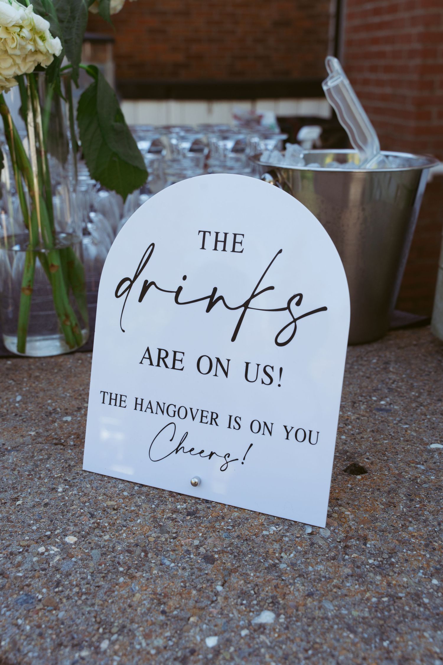 White paper signs with handwritten text 'The hangover is on us' displayed on a textured surface.