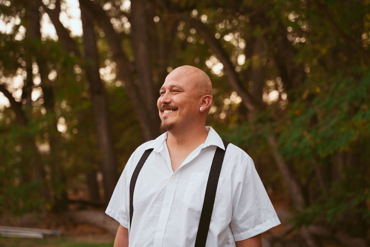 A casual outdoor portrait session in a natural wooded setting during golden hour.
