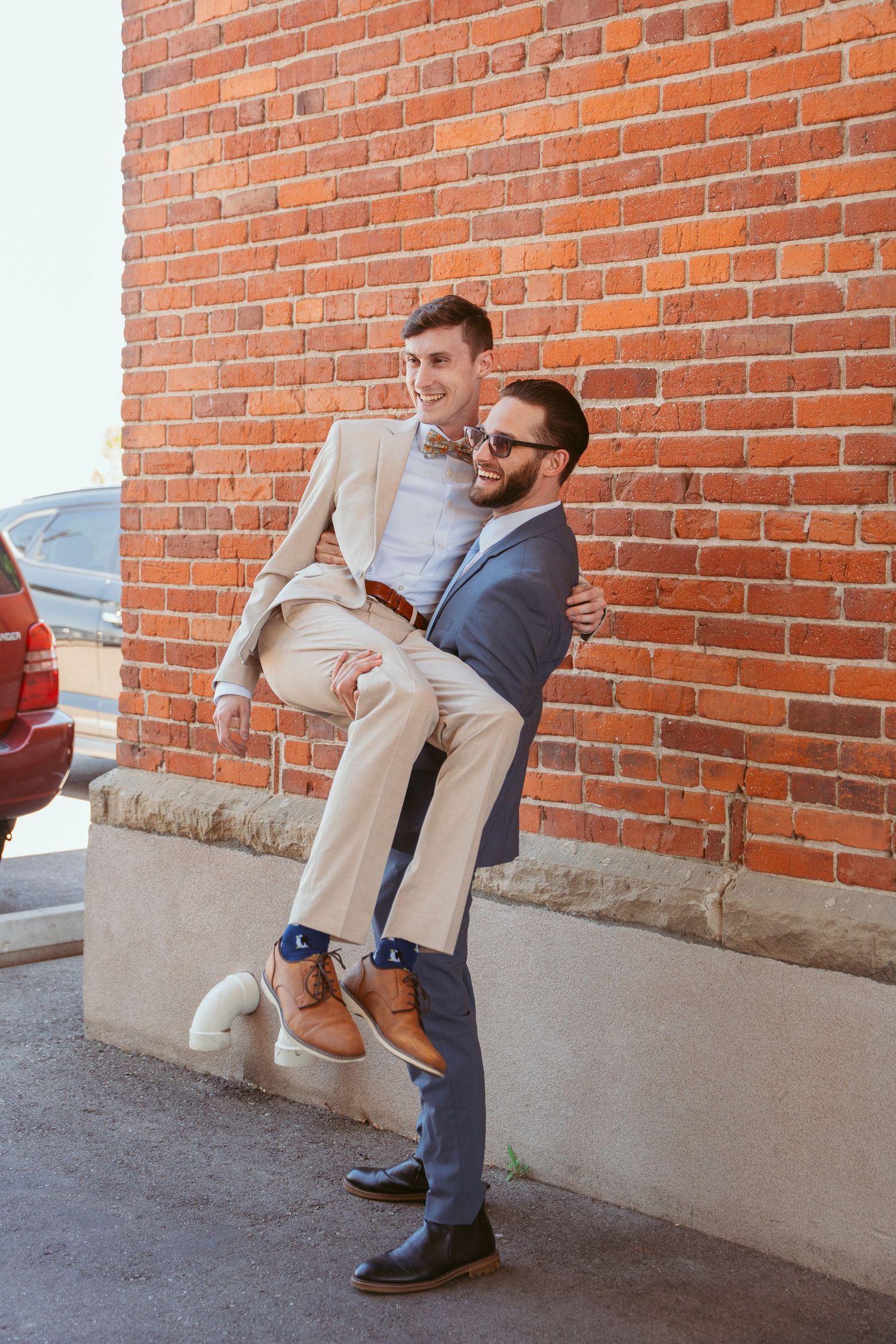 A sequence of playful poses against a brick wall showing someone leaning and jumping in casual attire.