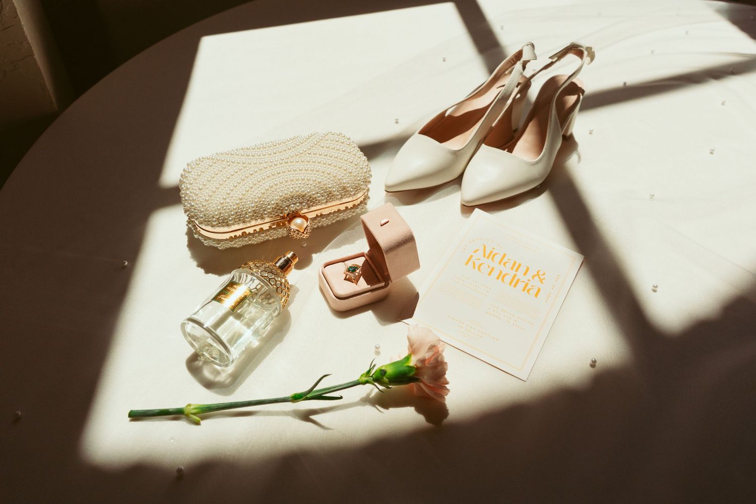 Artistically styled wedding details with perfume bottles and accessories in dramatic lighting.