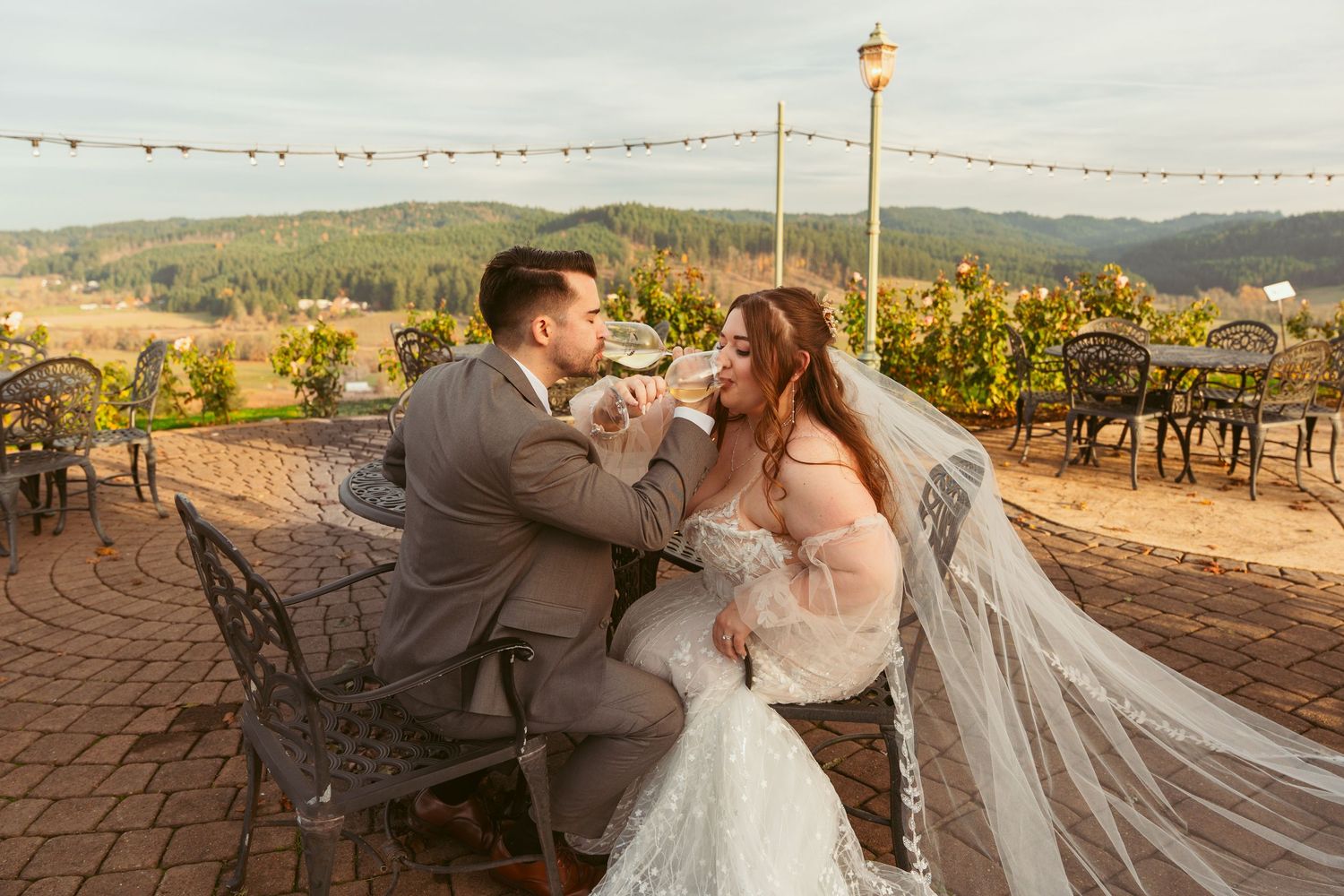 Bride and groom share playful moments during sunset photo session on outdoor terrace.