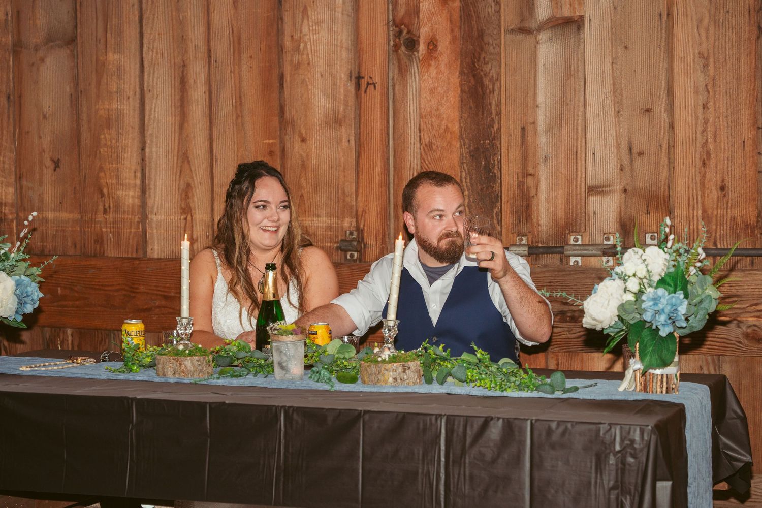 Elegant table settings with floral decorations at a rustic barn venue.
