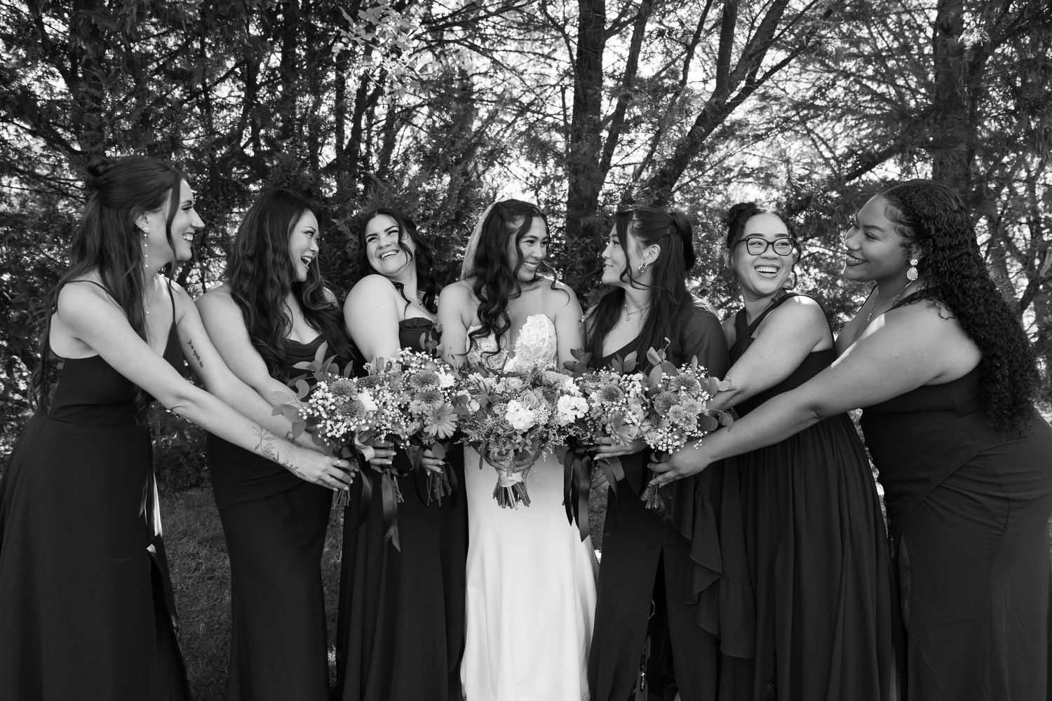 Black and white photo of bridal party in circle formation holding bouquets.