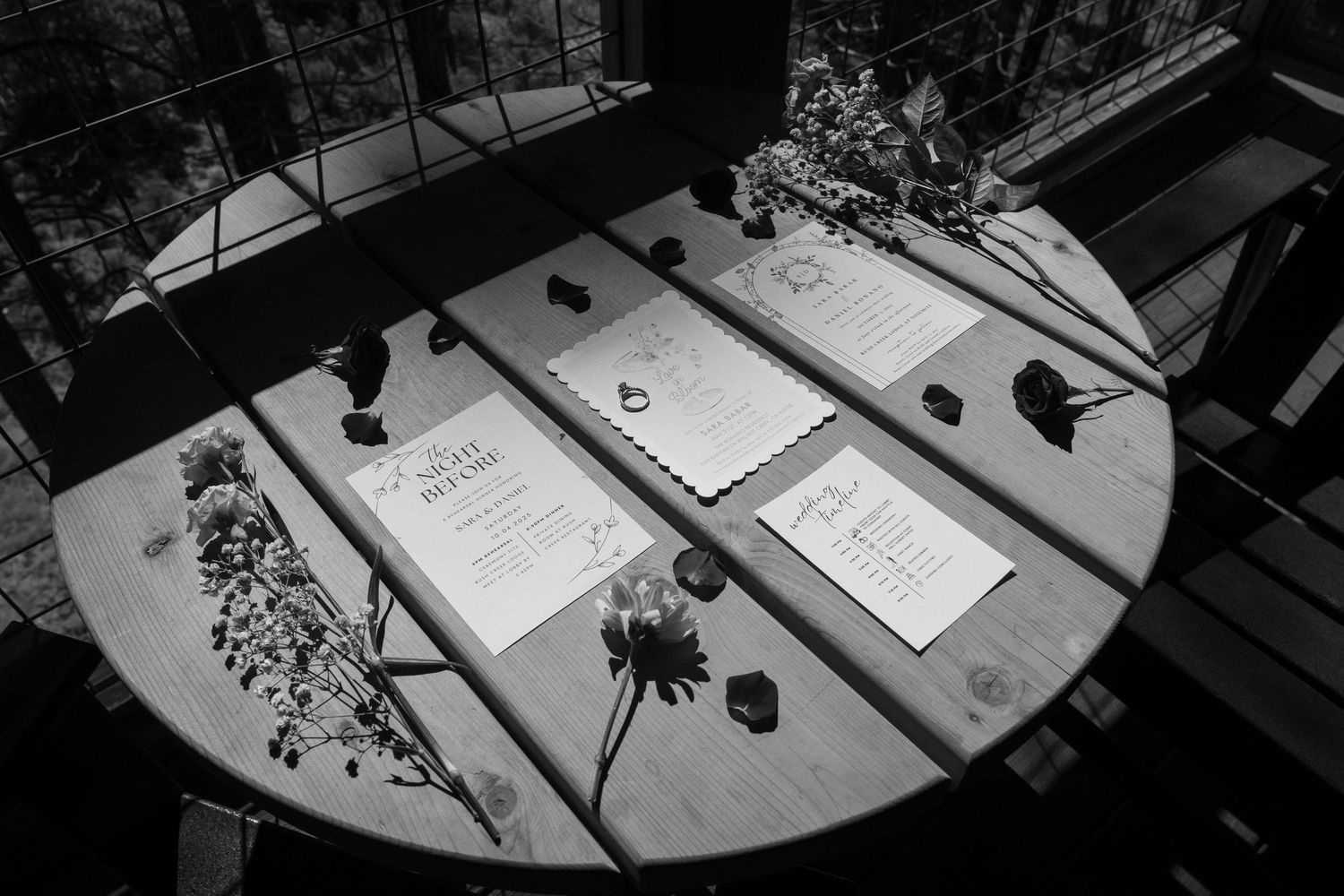 Black and white photo of wedding menus arranged on a table with soft lighting.