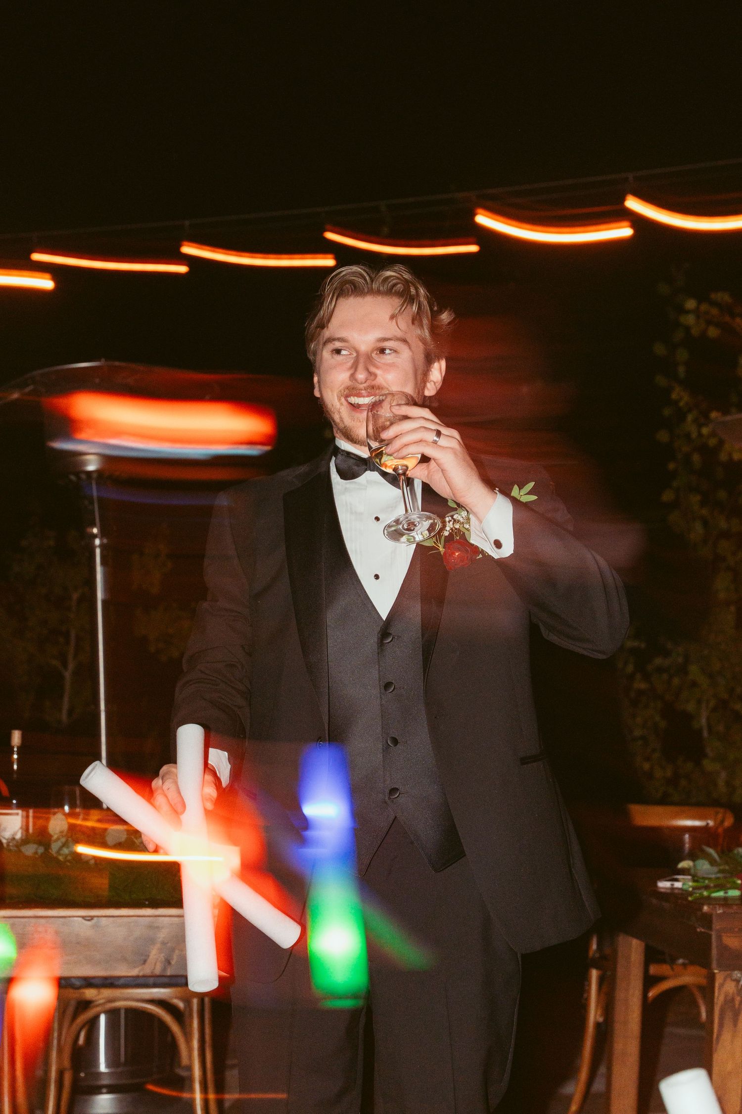 Wedding celebration at night with colorful light trails and glowing decorations.