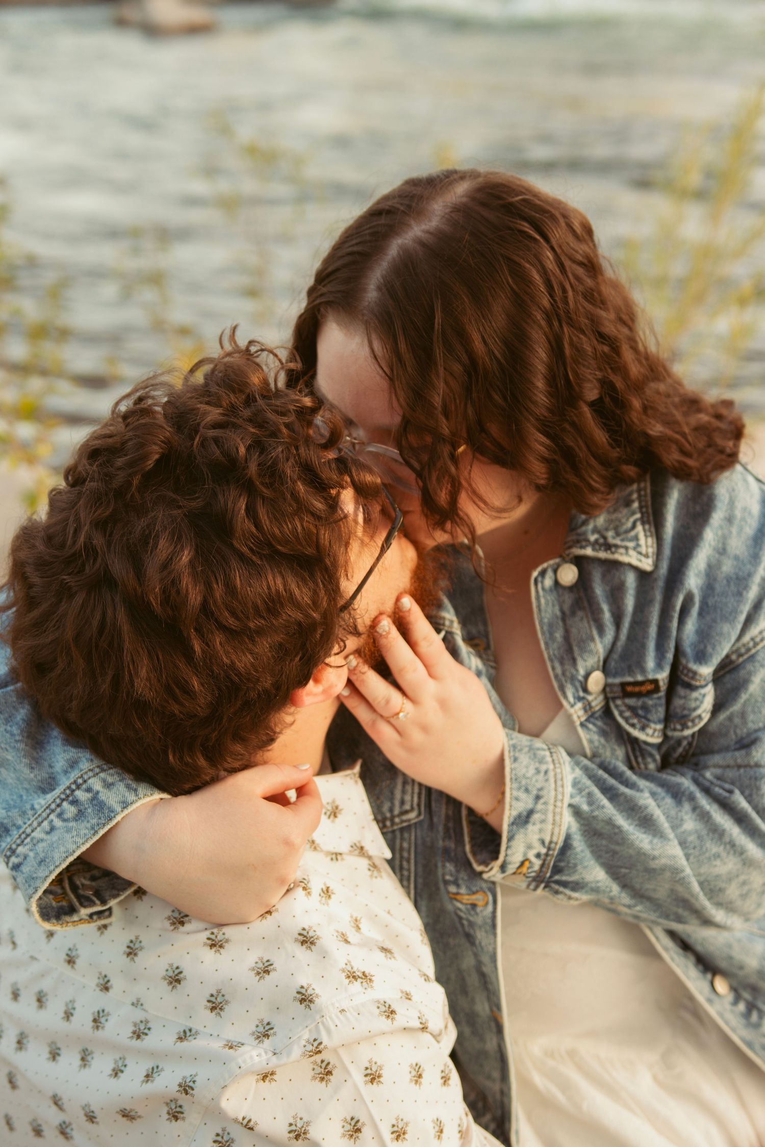 Close-up of a tender moment between two people in casual attire.