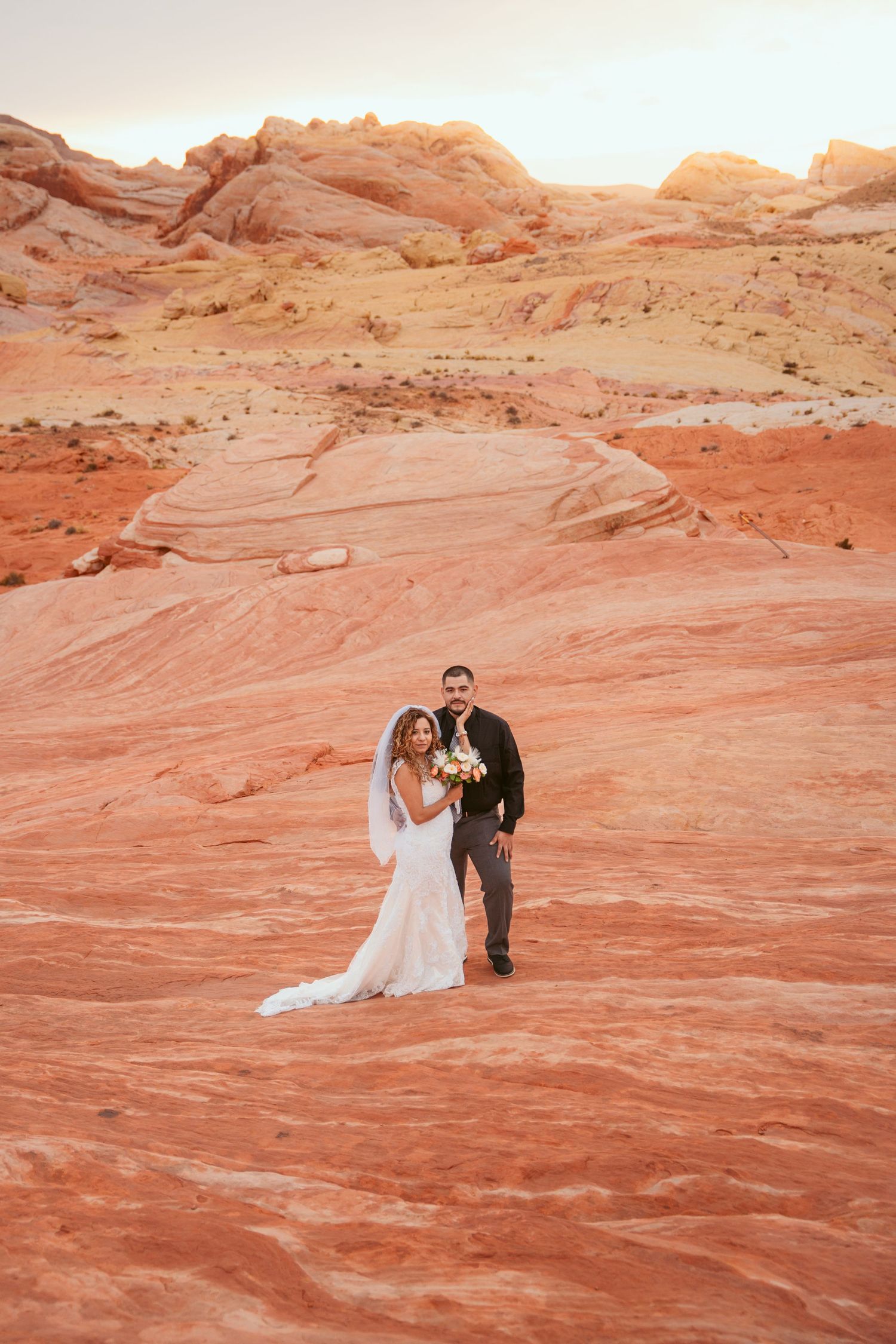 Wedding portraits on stunning red rock formations in the desert with flowing veil and dress.