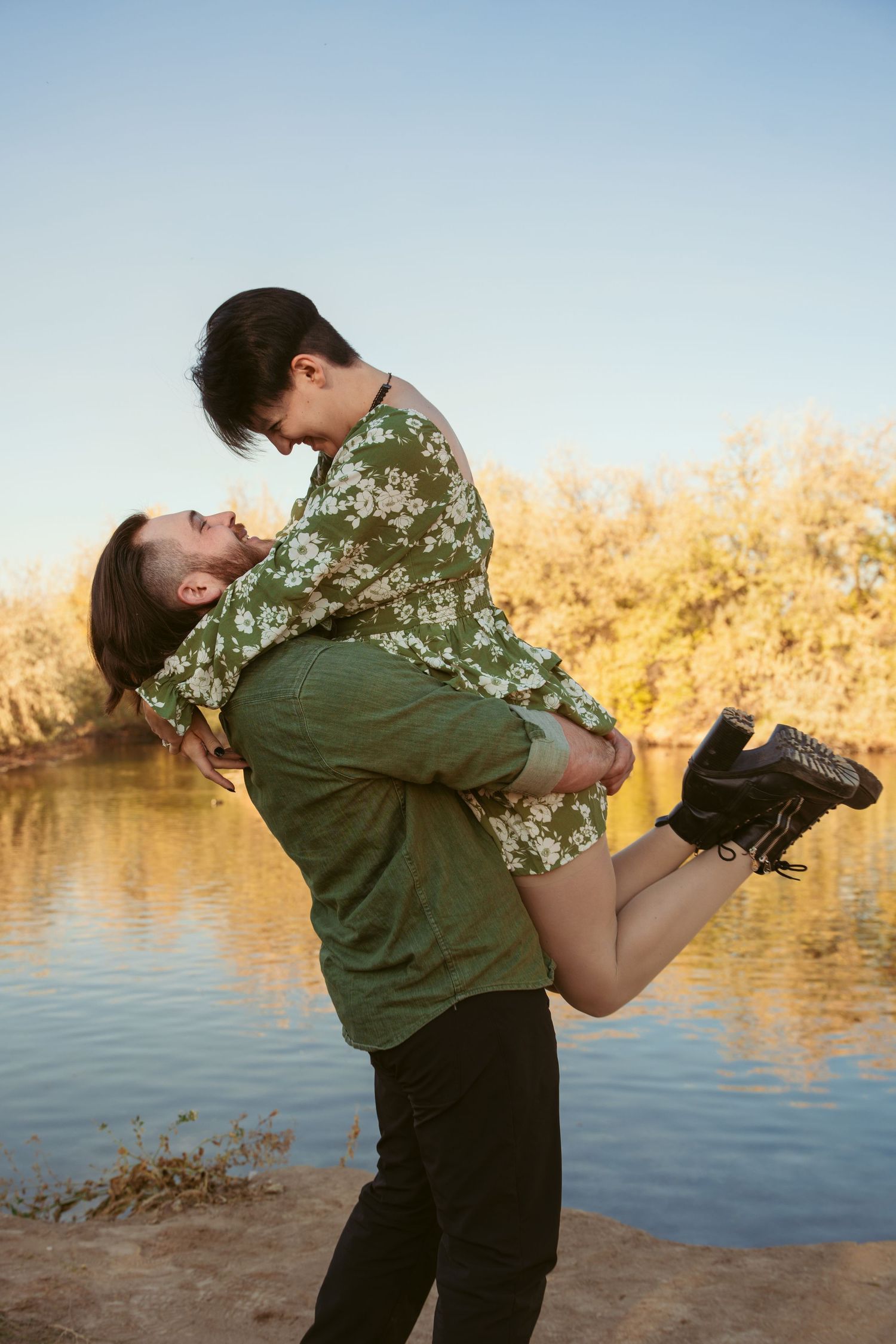 A playful dip pose near a tranquil lake during golden hour.