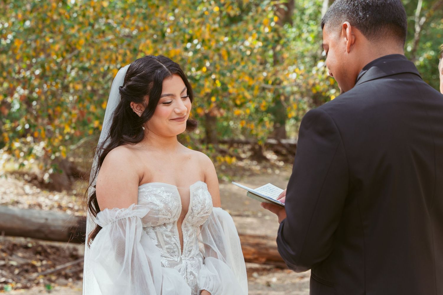 Wedding ceremony in a scenic fall setting with colorful foliage in the background.