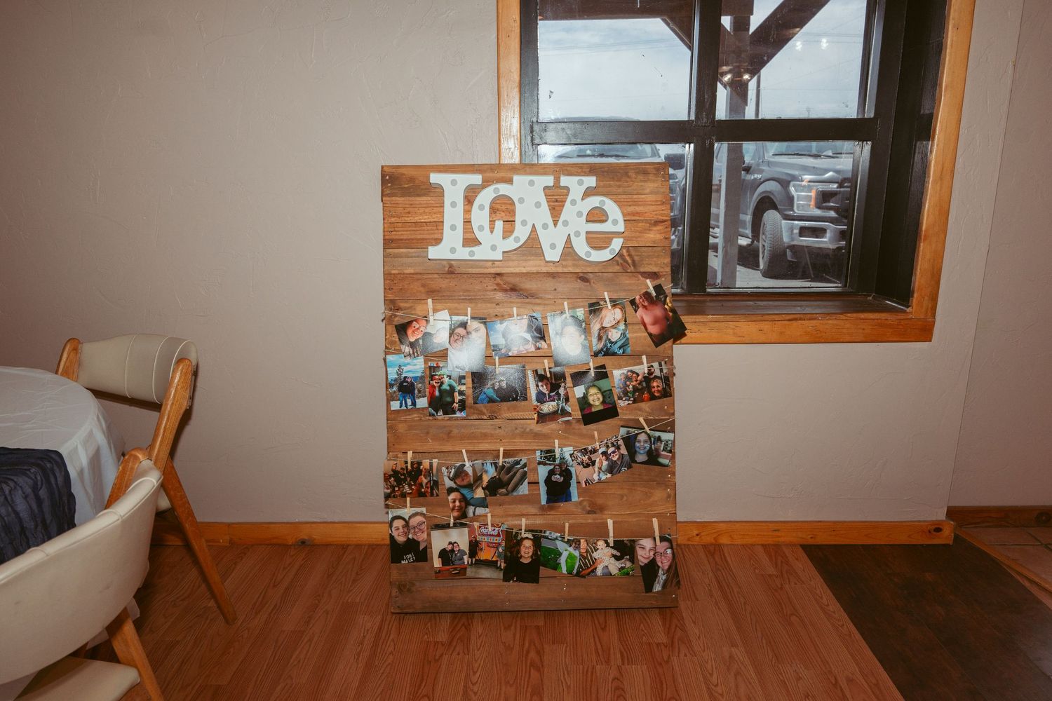 Rustic wedding venue interior with wooden beams and photo displays featuring the word 'love' on the wall.