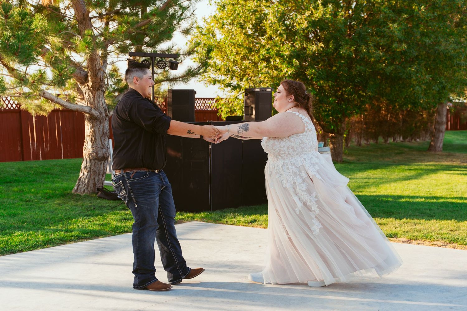 Couple dancing together on a white outdoor dance floor during a celebration.