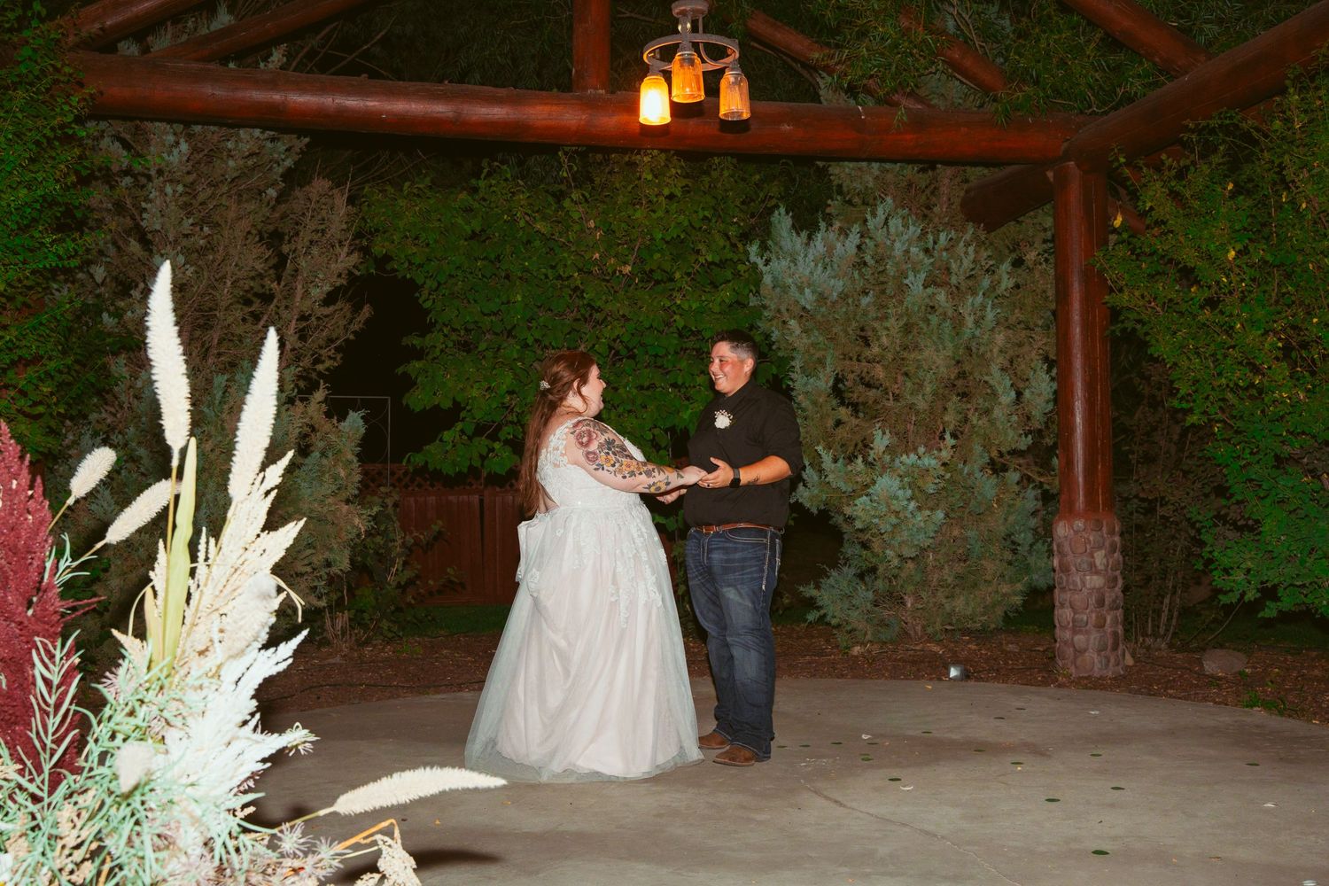 Wedding party members engaging in staged wrestling moves under outdoor lighting.