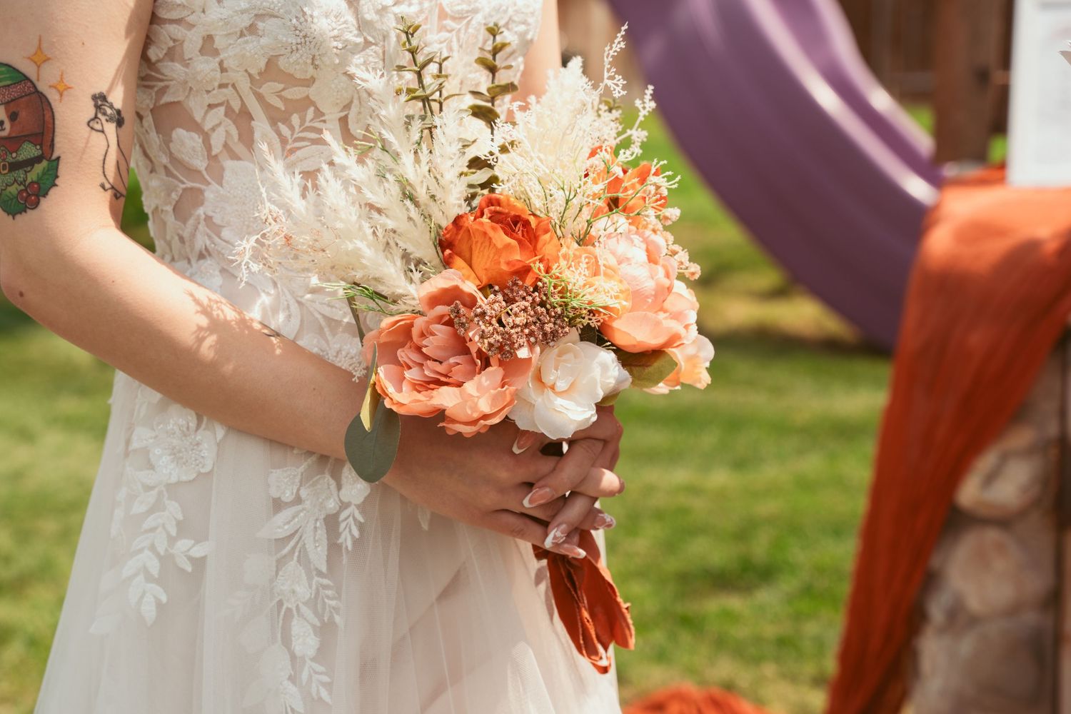 Close-up details of peach and coral colored wedding bouquet flowers.