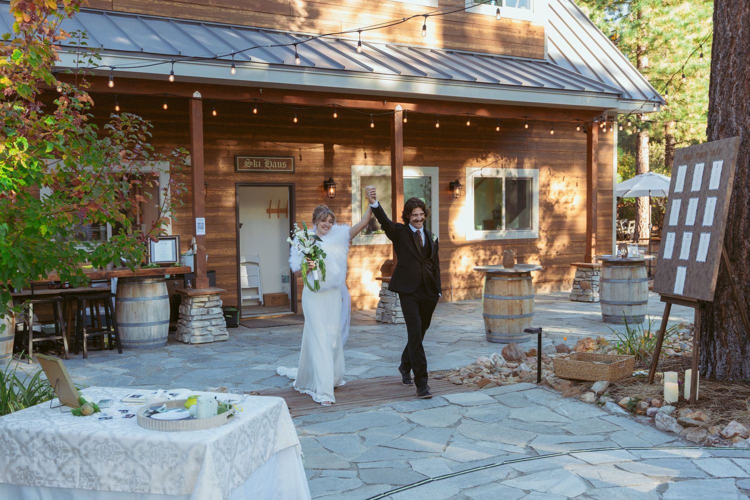 Rustic wooden lodge buildings with stone foundations nestled among trees in a mountain setting.