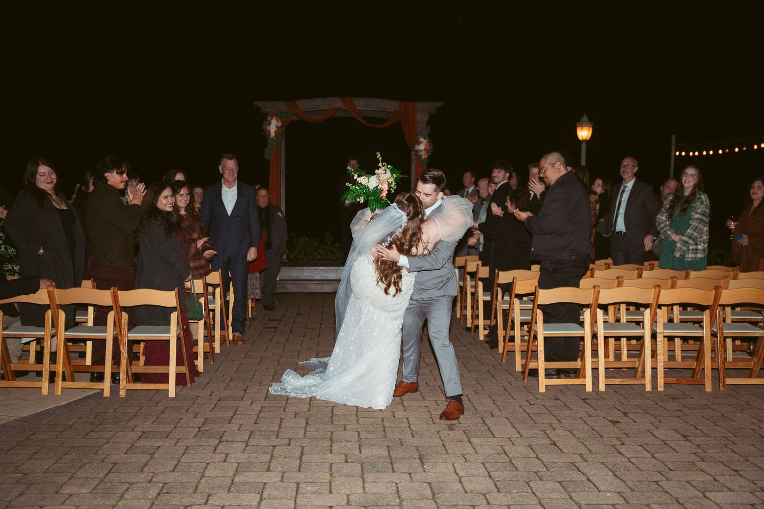 Newlyweds sharing a celebratory moment during their ceremony exit.
