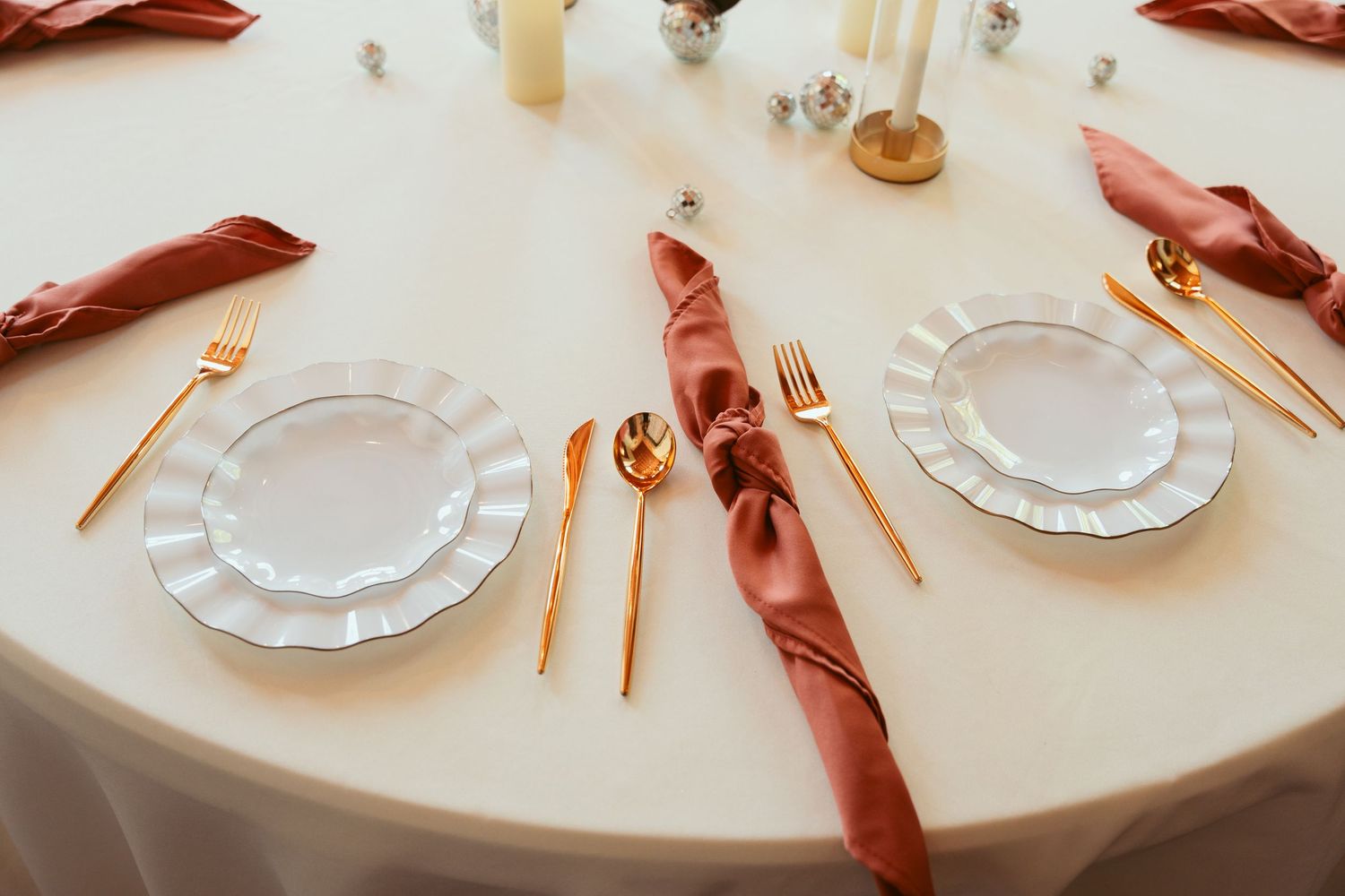 Elegant table settings with gold flatware and crystal plates for a formal reception.