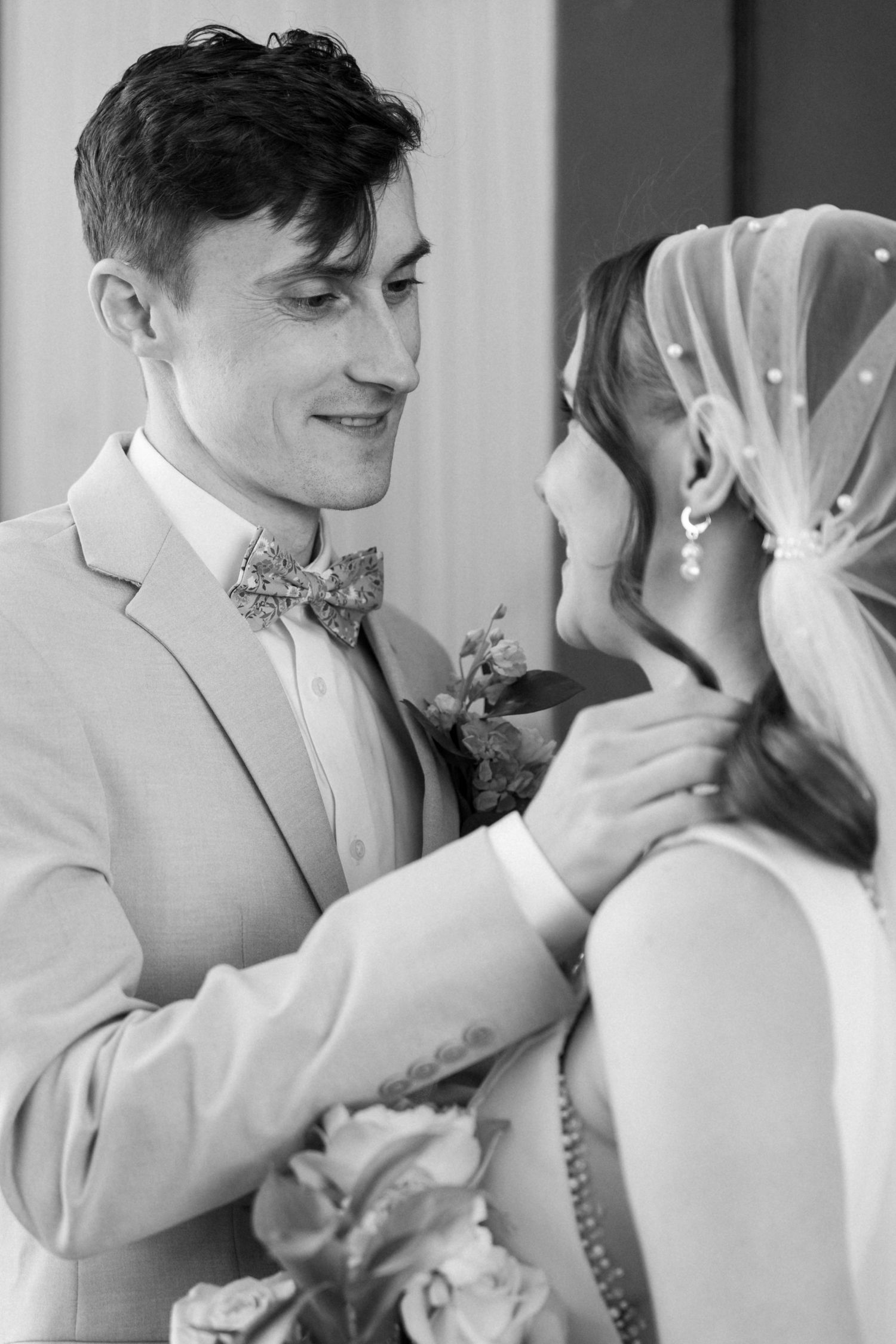 Black and white sequence of tender wedding moments with a light-colored suit and veil.