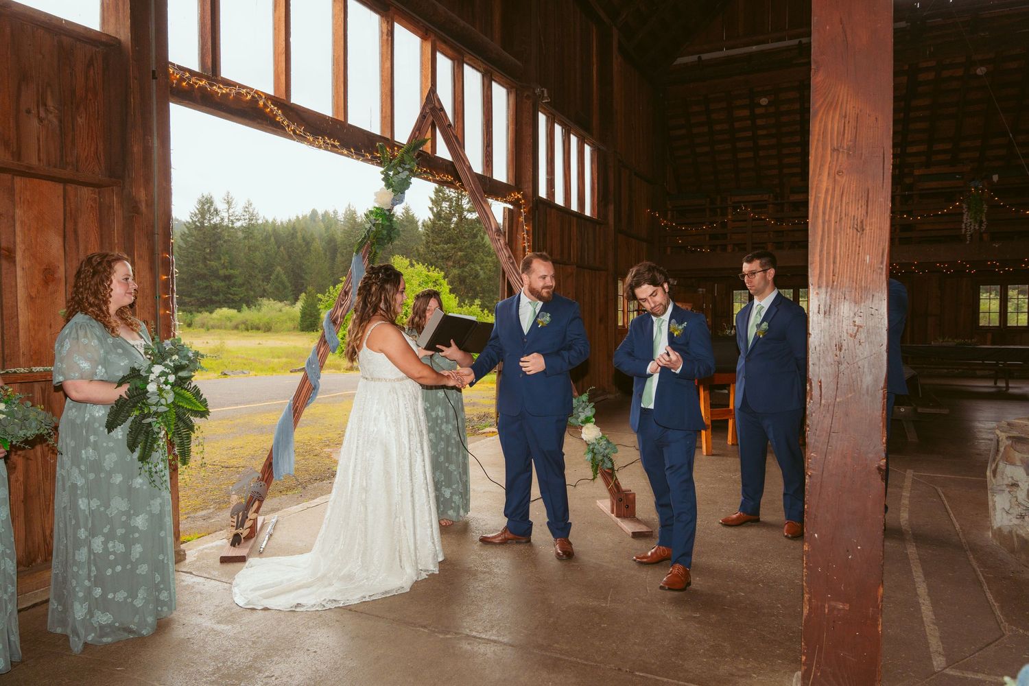 Wedding ceremony setup in a rustic barn with wooden beams and natural lighting.