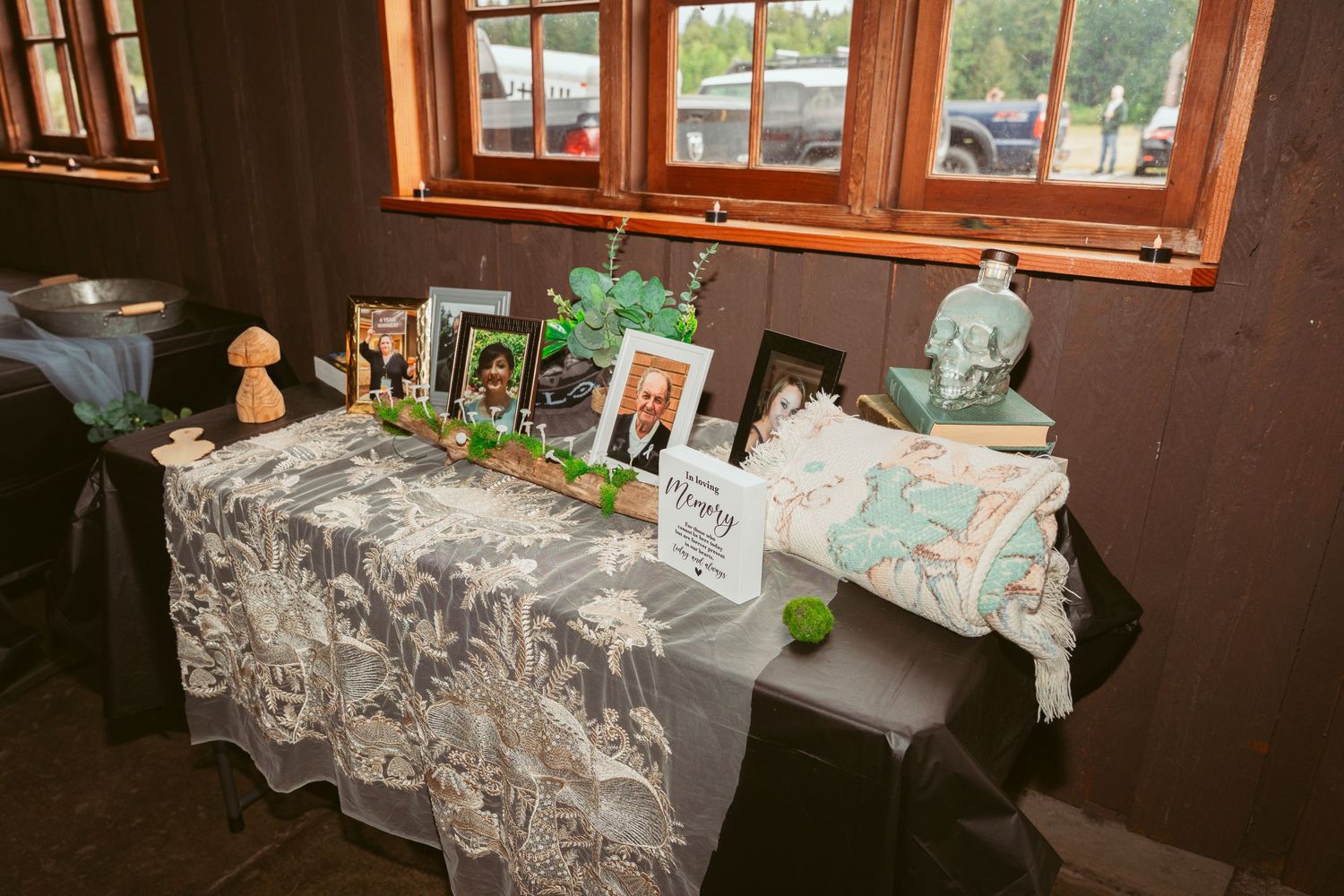 Wedding reception tables decorated with elegant white linens and floral arrangements in a rustic wooden venue.