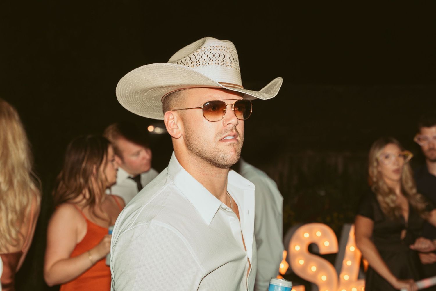 People dancing at a western-themed party with cowboy hats.