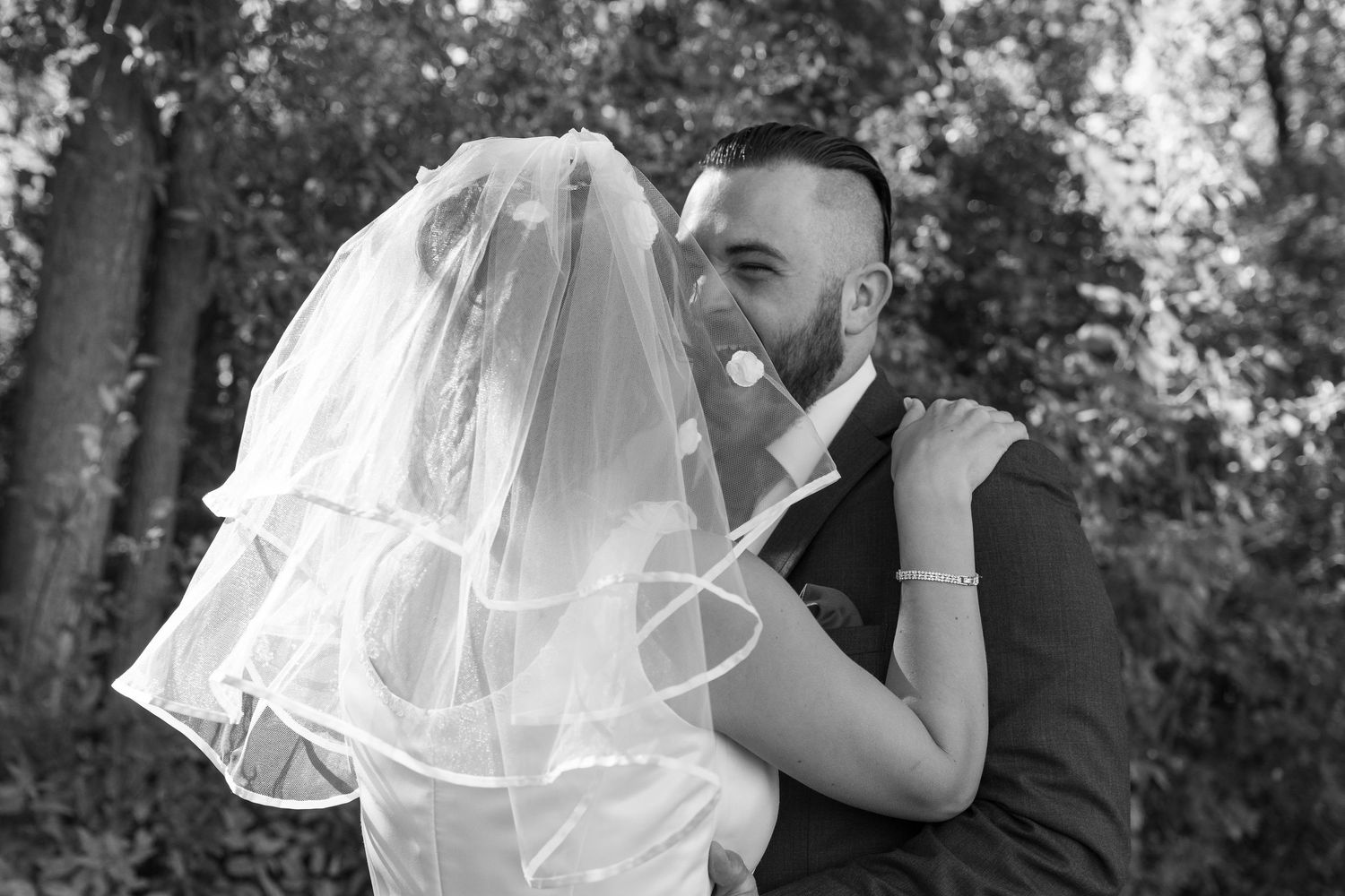 Wedding couple sharing an intimate moment under autumn trees.