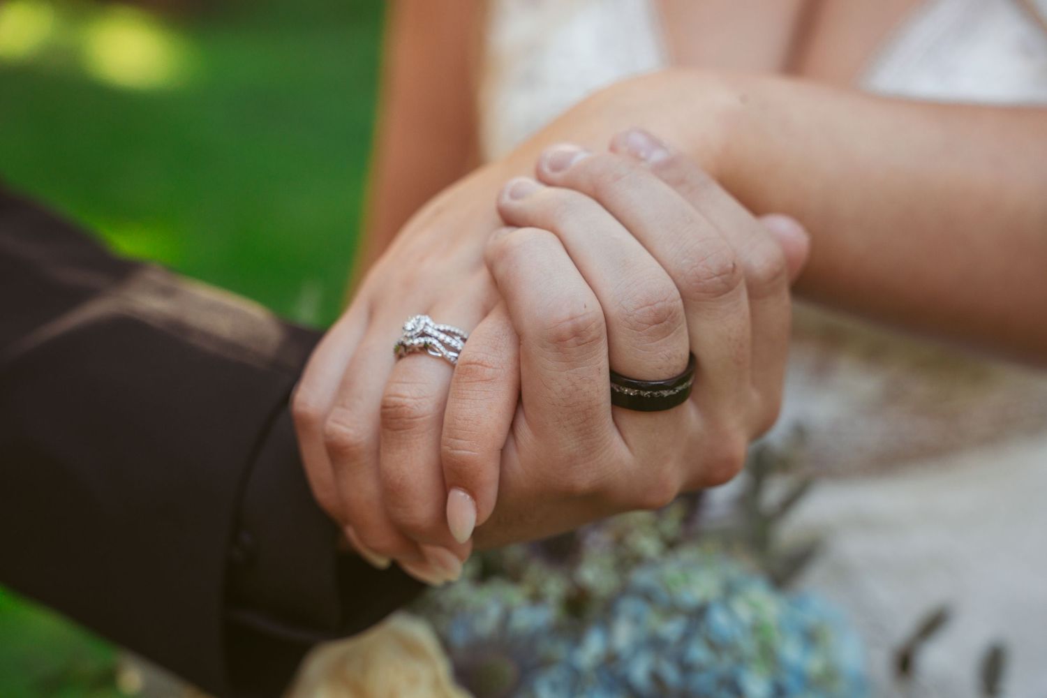 Close-up shots of wedding rings and joined hands during an outdoor ceremony.