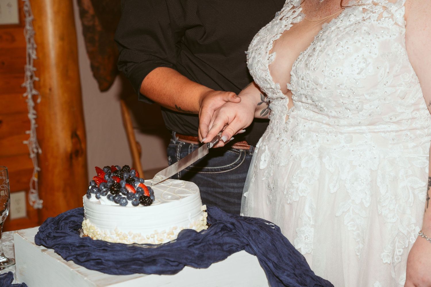 Close-up details of a white lace wedding dress with intricate beading and embellishments.