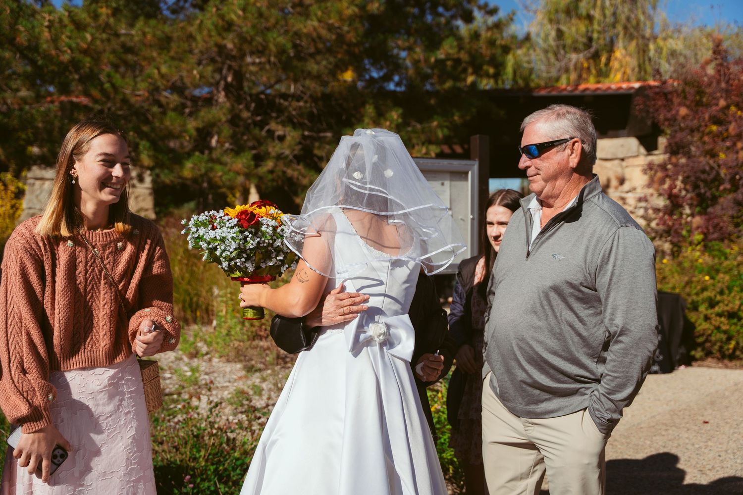 Wedding celebration candid shots on outdoor path with natural fall scenery.