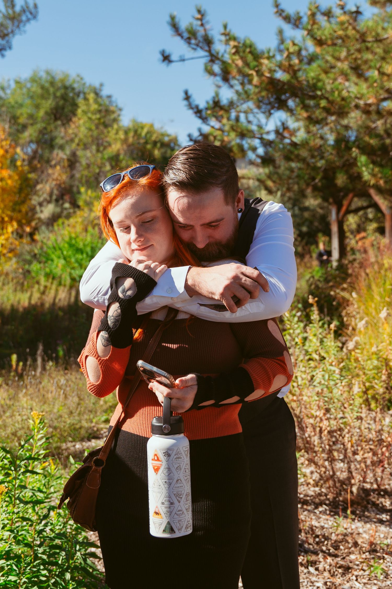 Group hugs and emotional moments captured in outdoor autumn setting.