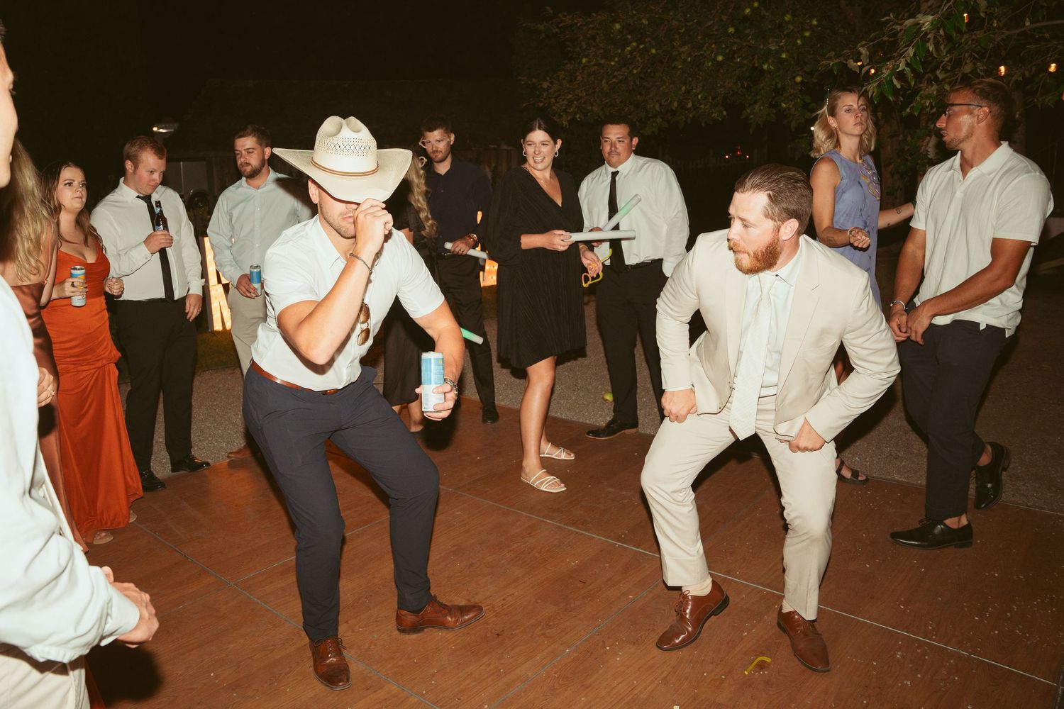 Crowd dancing and moving on an outdoor dance floor at night.